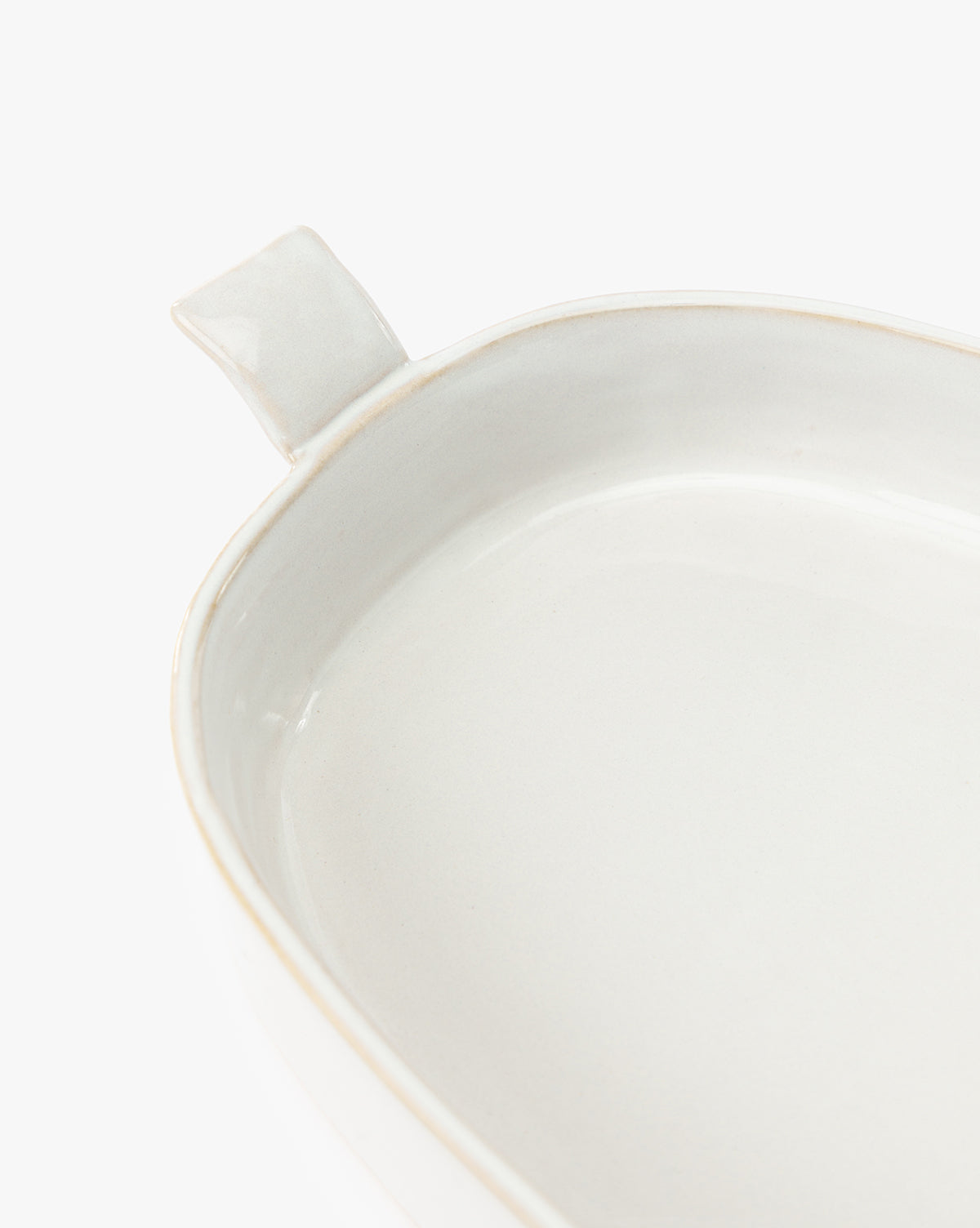 A close-up of the 1.5 Quart Stoneware Baker, featuring a single handle and white ceramic finish, ideal for oven-to-table use, displayed against a plain white background, by McGee & Co.