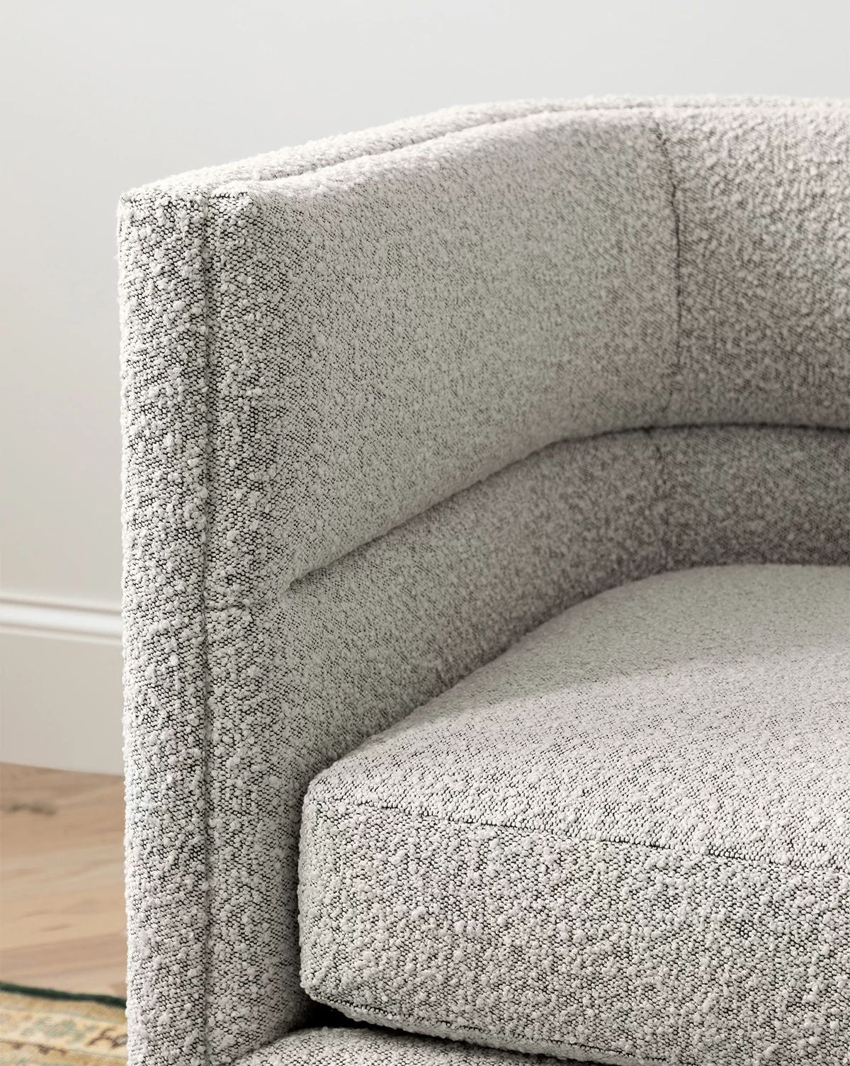 Close-up of the Makerspalm Claremont Modular Sofa 99 in light gray, featuring textured customizable fabric, plush cushioning, and clean lines where the seat, backrest, and armrest meet. McGee & Co.