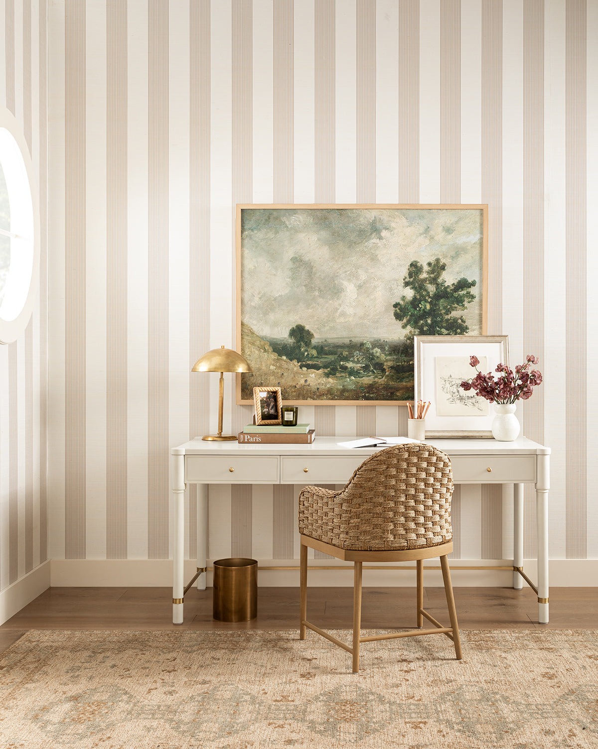 Beige and white striped walls complement the wooden floor covered by the Wilshire Natural Hand-Tufted Wool Rug for comfort and durability, by McGee & Co.