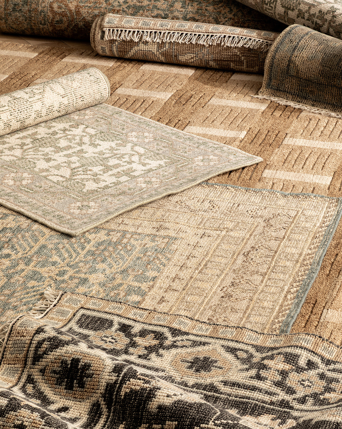 The Orsino Hand-Knotted Rug is displayed in earthy beige, brown, blue, and black tones, featuring geometric and intricate patterns that highlight its artisanal craftsmanship, by McGee & Co.
