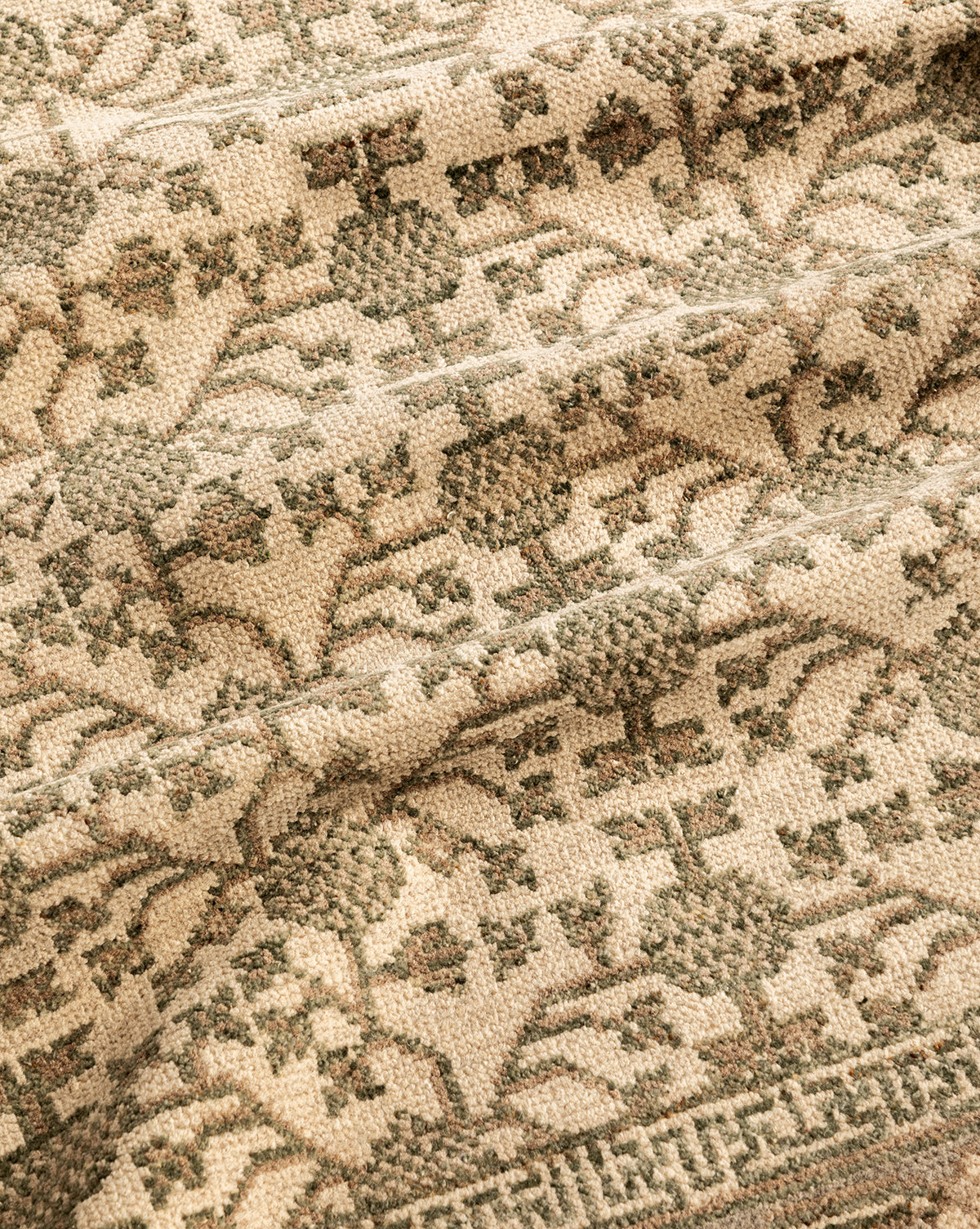 A close-up of the Orsino Hand-Knotted Rug highlights its beige background, intricate gray floral and geometric patterns, soft texture, and detailed craftsmanship, by McGee & Co.