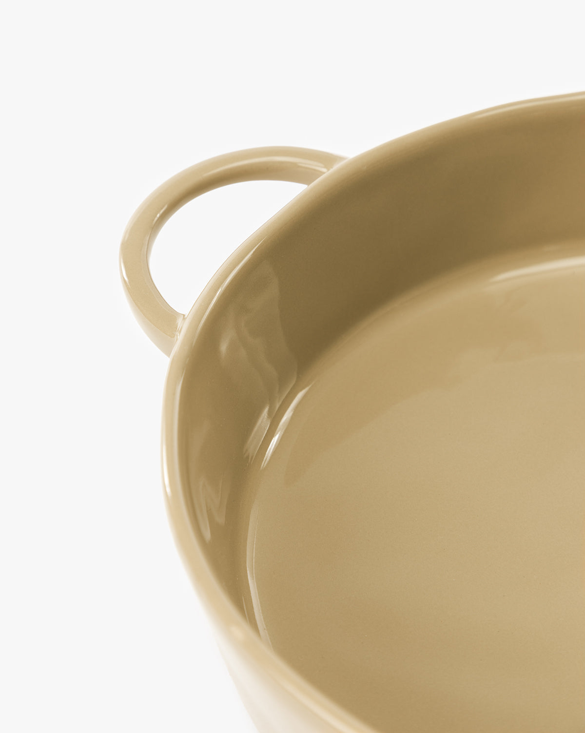 Close-up of a beige 2 Quart Stoneware Baker (Set of 2) with handle, highlighting its smooth, glossy surface and rounded edge against a white background, by McGee & Co.
