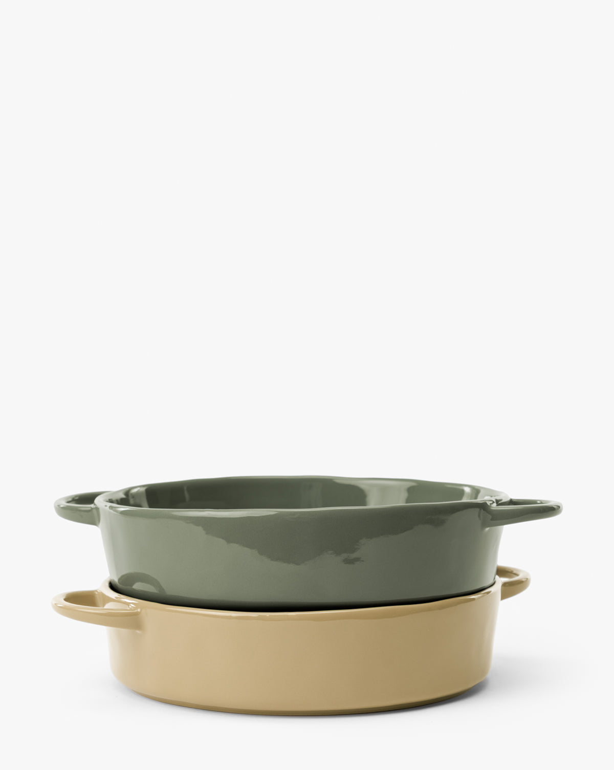 The 2 Quart Stoneware Baker (Set of 2) features two oval bakers with handles, stacked on a white background; one is green, the other beige, both with a glossy finish by McGee & Co.