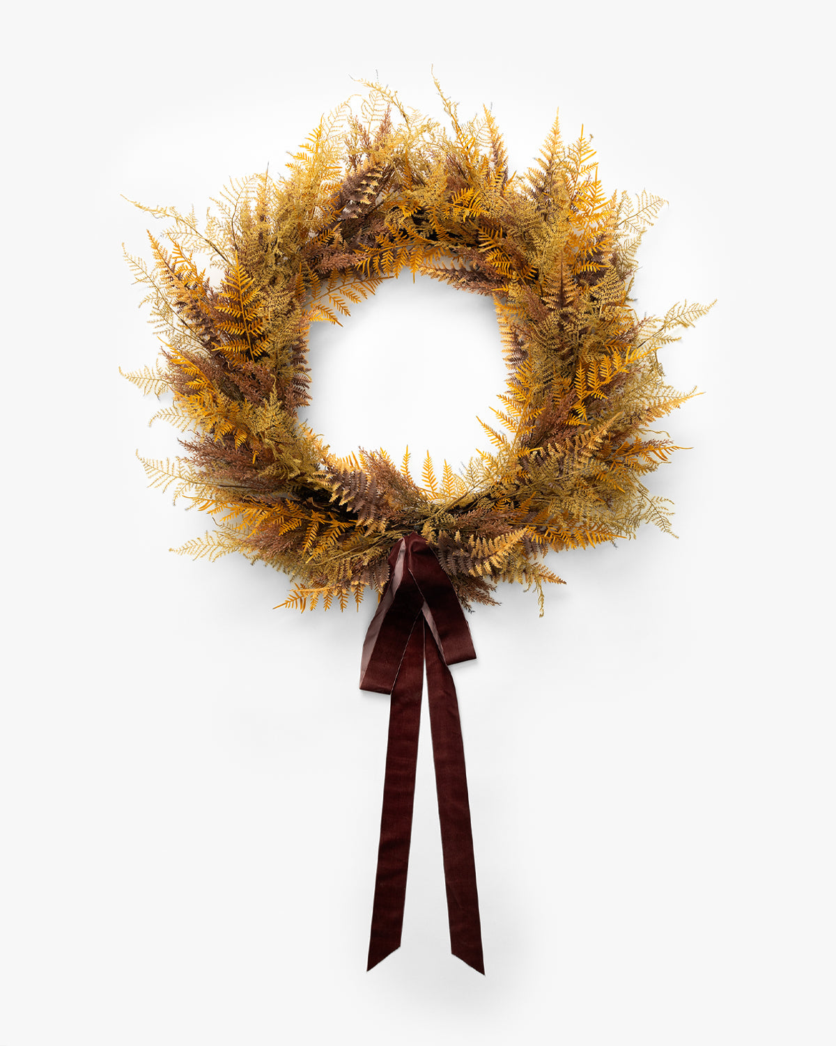 The 30 Faux Golden Fern Wreath, featuring yellow and brown dried-look ferns and a dark brown ribbon bow, is ideal for fall décor or as an entryway accent against a plain white background, by McGee & Co.