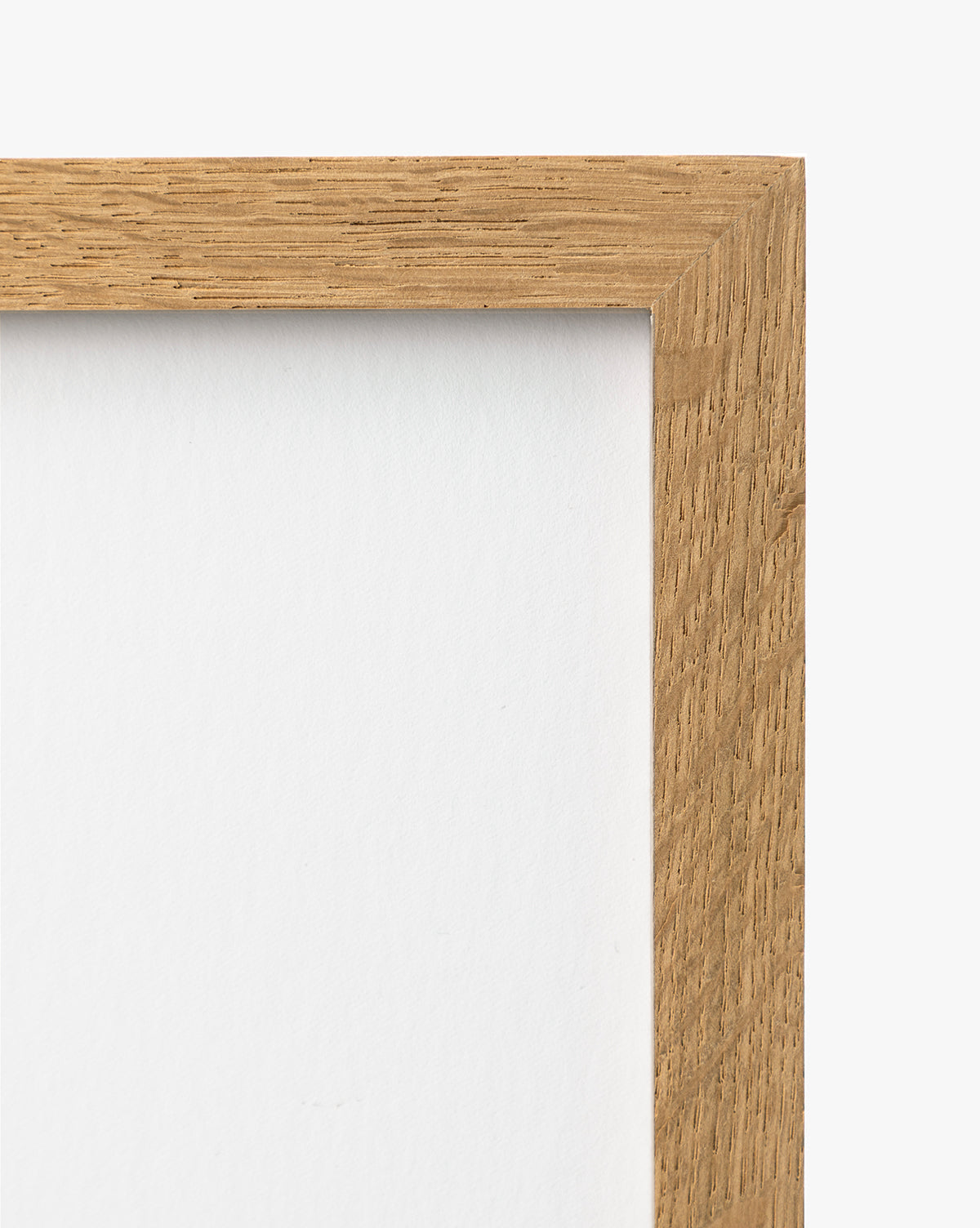 A close-up of the top right corner of the A River Runs Through wooden picture frame showcases its natural grain against a white backdrop, with a white background inside the frame—perfect for highlighting abstract landscapes or earthy tones, by McGee & Co.