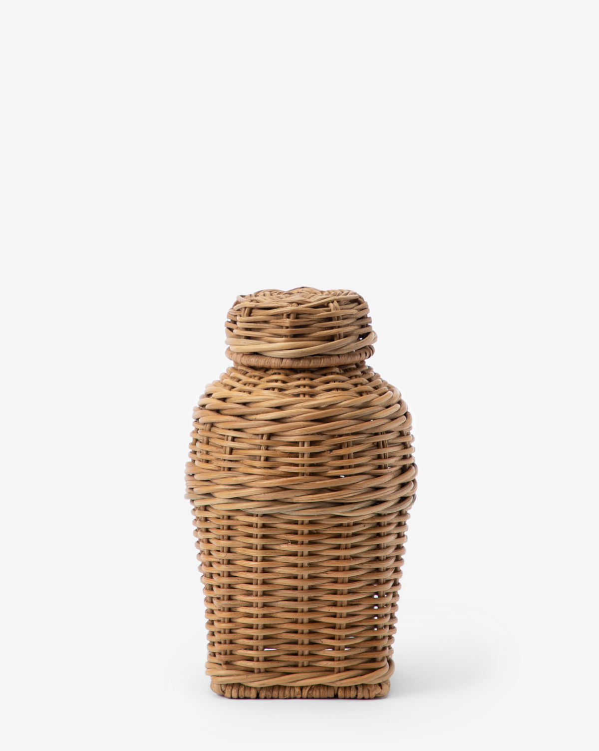 The Ahnamia Wicker Jar is a handcrafted, cylindrical container with a tightly fitted lid, made from light brown woven wicker, shown upright against a plain white background.