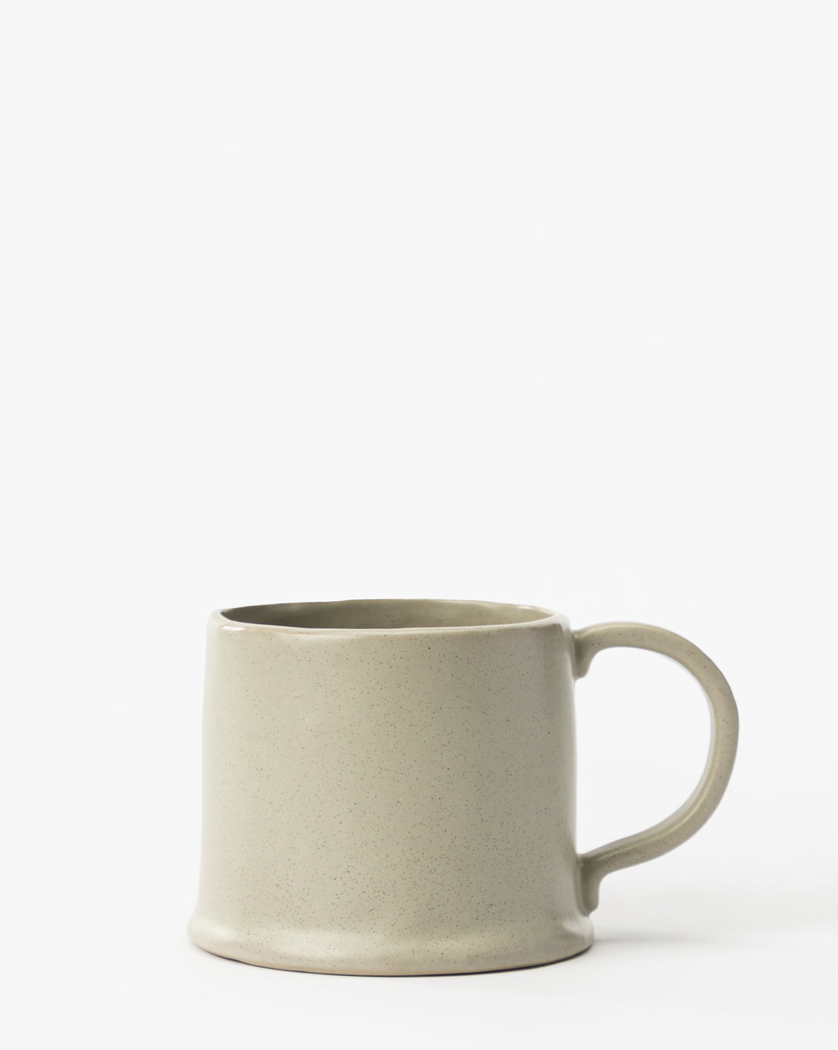 The Aiden Soft Gray Mug features a slightly curved, minimalist design with a large handle. Crafted from glazed ceramic, this elegant mug adds timeless style to any setting and is shown on a white background by McGee & Co.