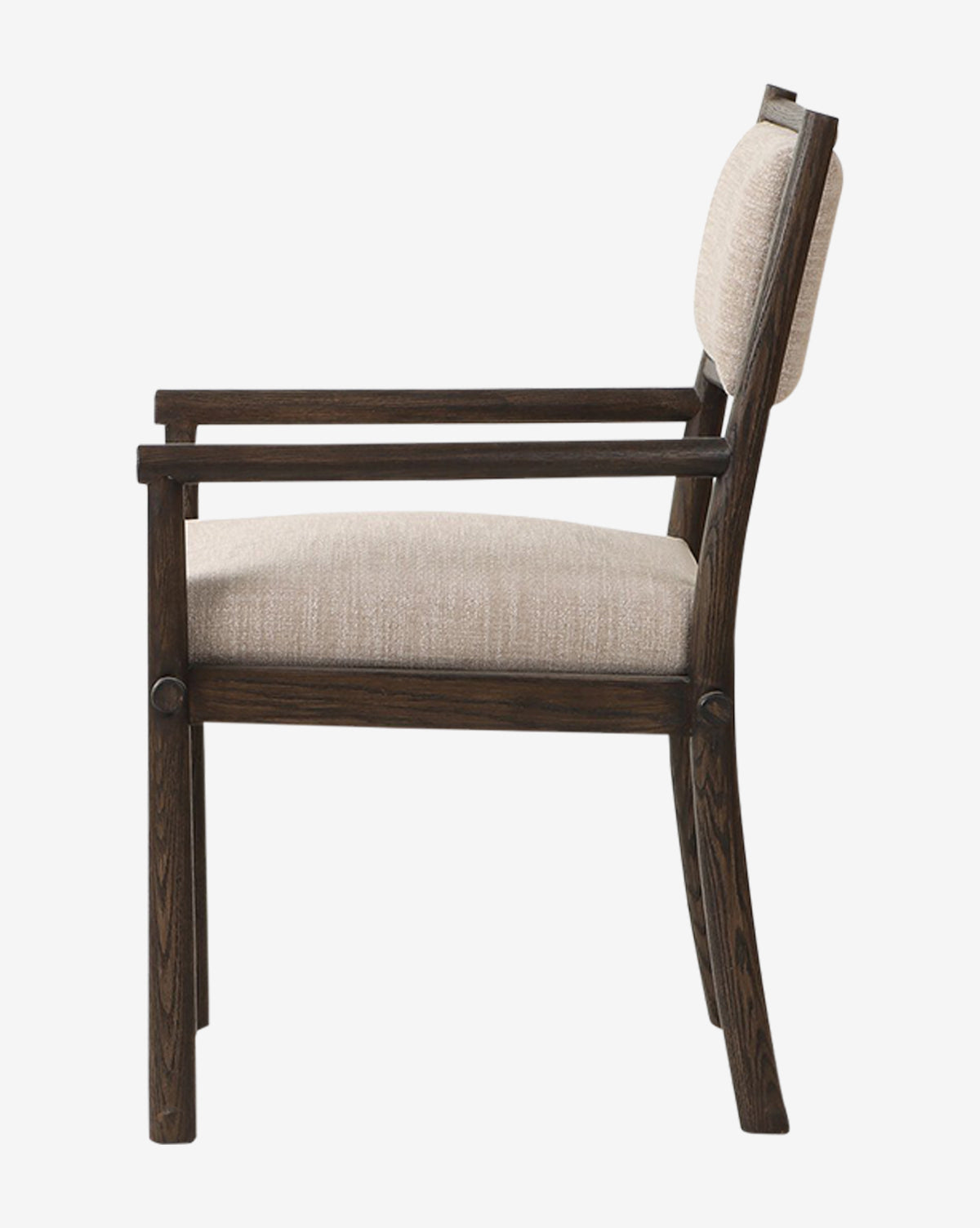 Side view of the Ailsa Dining Chair with armrests, featuring a cushioned seat and backrest in light beige fabric. Its dark oak frame complements the simple, modern design—ideal as a contemporary dining chair, by McGee & Co.