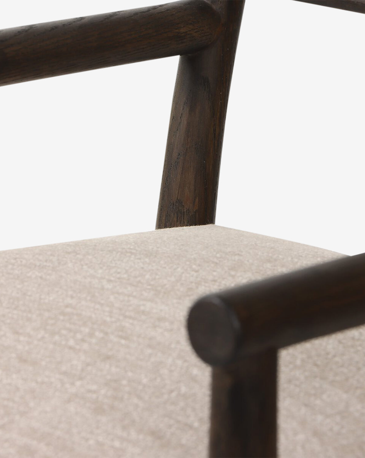 Close-up of the Ailsa Dining Chair with dark oak armrests and a light beige upholstered seat, set against a white background. This modern chair combines elegance and comfort, by McGee & Co.