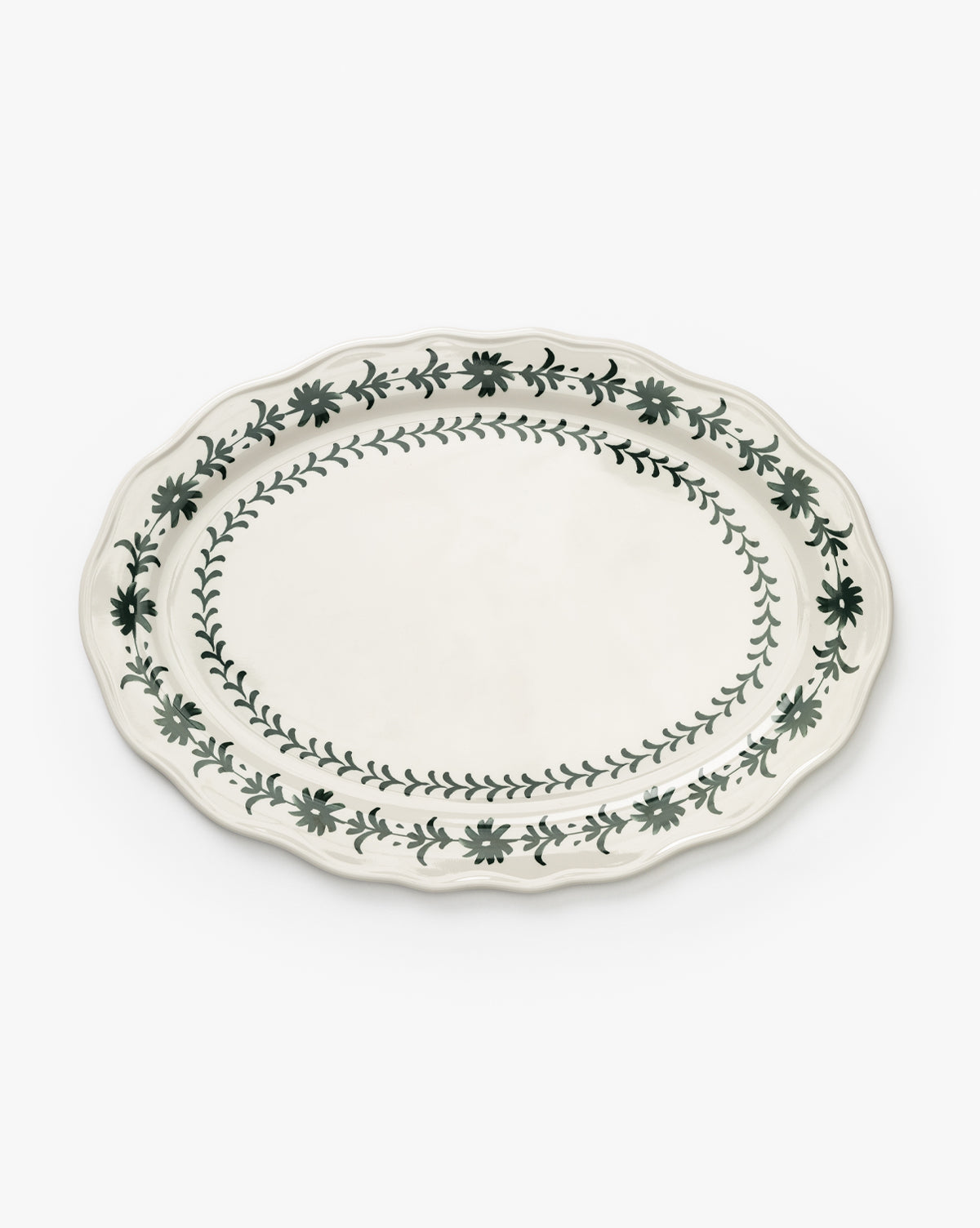 The Alba Melamine Platter is an oval plate with a scalloped edge, adorned with green floral vine motifs along the rim and inner border on a white background, by McGee & Co.
