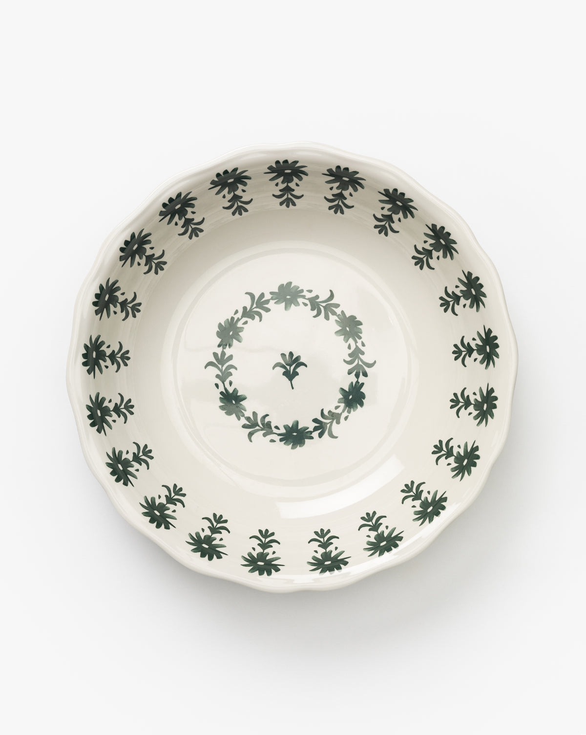The Alba Melamine Serving Bowl is round and white with a scalloped edge, featuring a green floral motif along the rim and a central circular floral design, shown against a plain white background by McGee & Co.
