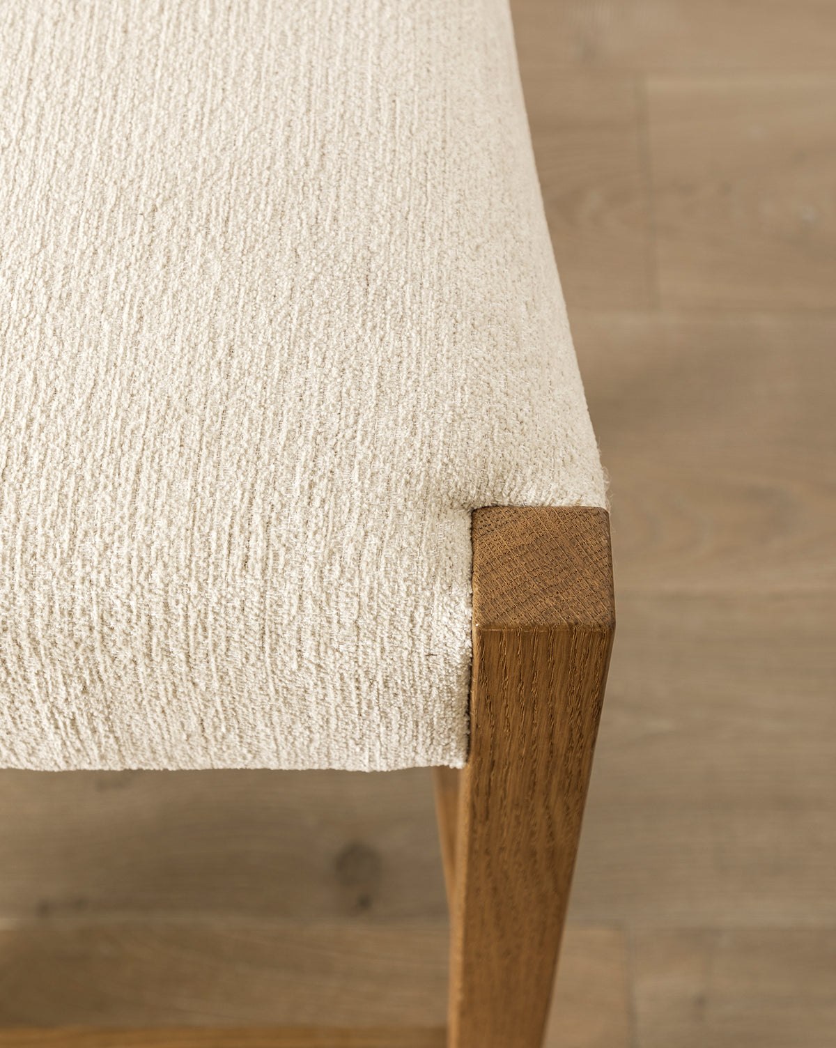 Certainly! Here’s your blended caption, with McGee & Co. smoothly incorporated at the end: Close-up of the Makerspalm Alberta Counter Stool, featuring beige textured fabric upholstery and honey oak legs, on a light wood floor. The image highlights the fabric’s texture and smooth wood grain. McGee & Co.