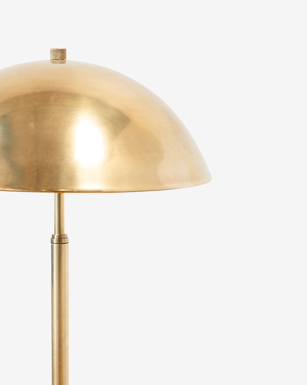 A close-up of the Aldorno Floor Lamp featuring a modern design with a shiny, dome-shaped brass shade and a matching straight brass stand, shown against a plain white background, by McGee & Co.