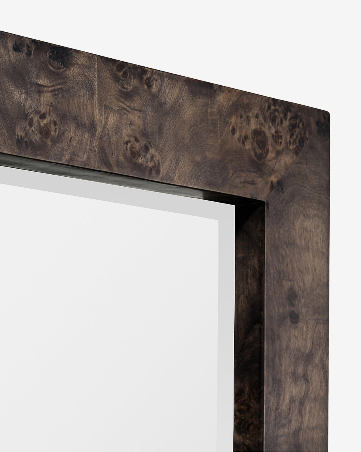 Close-up of the top right corner of the Alexia Rectangular Mirror, featuring a thick, dark burl wood frame with a natural grain pattern. This striking statement piece stands out against a plain white background, by McGee & Co.