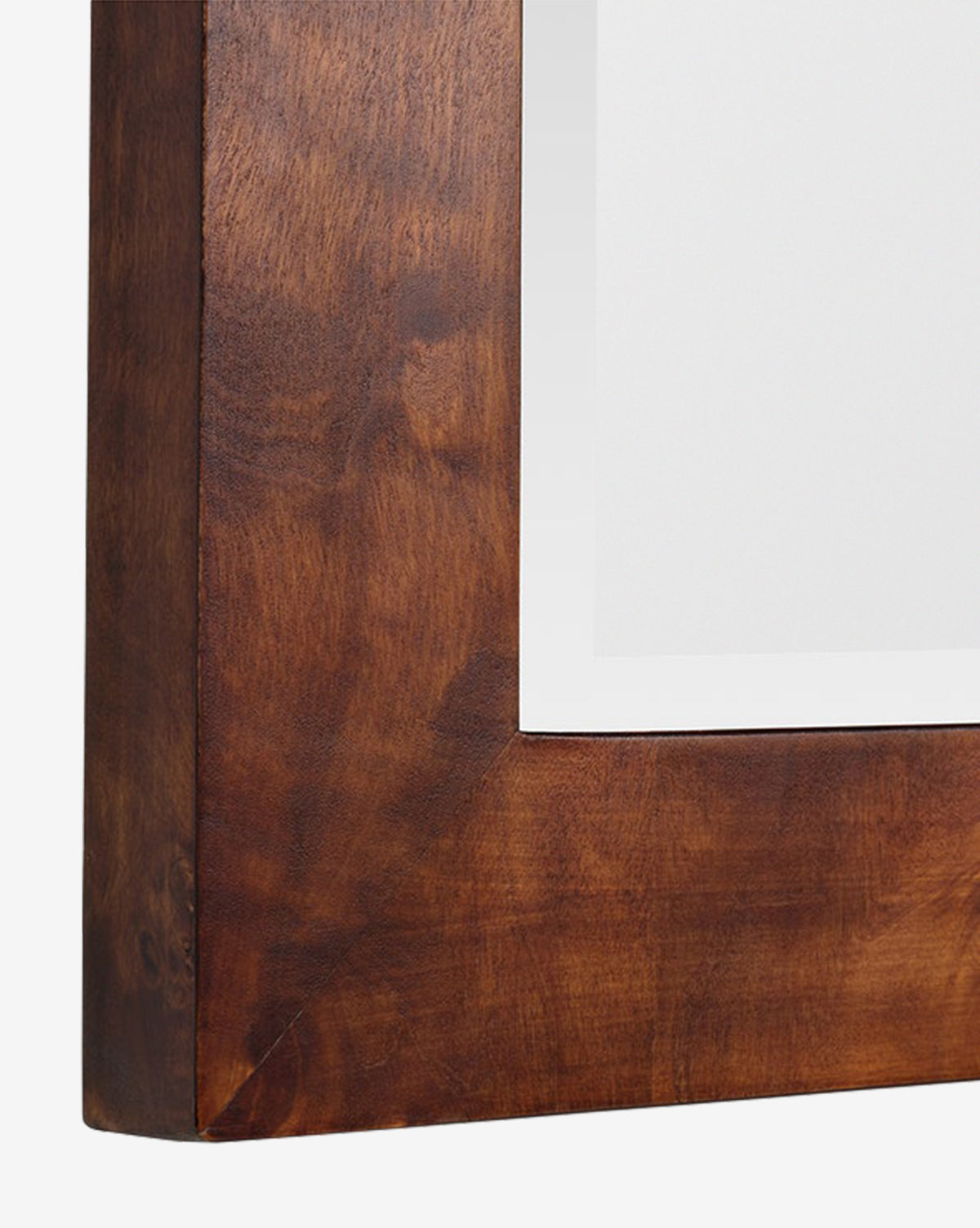 Close-up of the corner of the Alexia Rectangular Mirror, featuring a smooth, polished burl wood frame and a white mat—an elegant statement piece for any space, by McGee & Co.