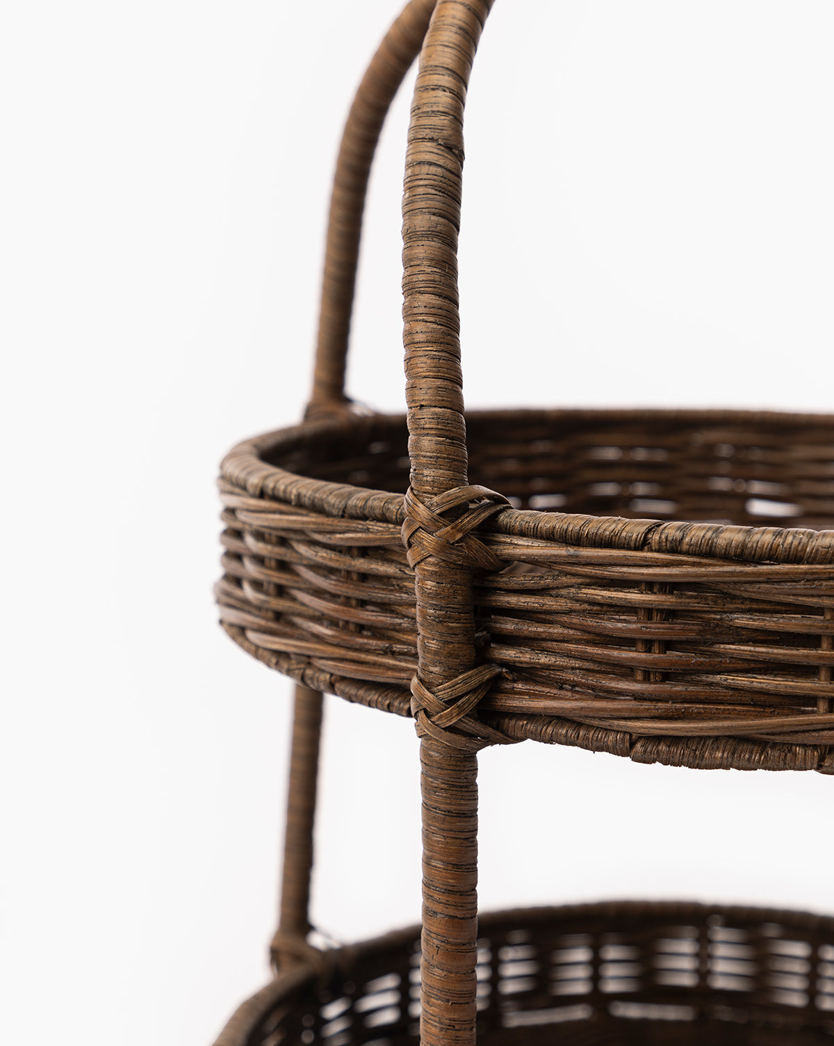 Close-up of the Aneesa Two-Tiered Wicker Tray with a handle, highlighting its detailed craftsmanship and texture against a white background—a stylish decorative serving tray for any setting, by McGee & Co.