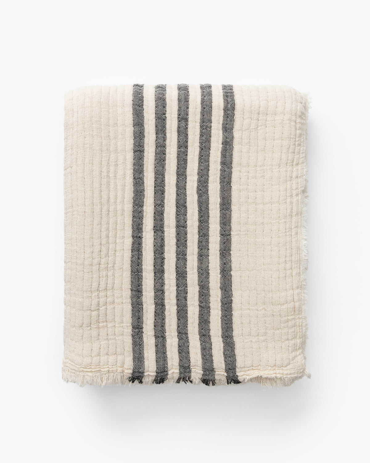The Anneliese Striped Throw by Creative Co-op features cream-colored cotton with four vertical dark gray stripes and slightly frayed edges, shown folded on a white background for a luxe home decor accent by McGee & Co.