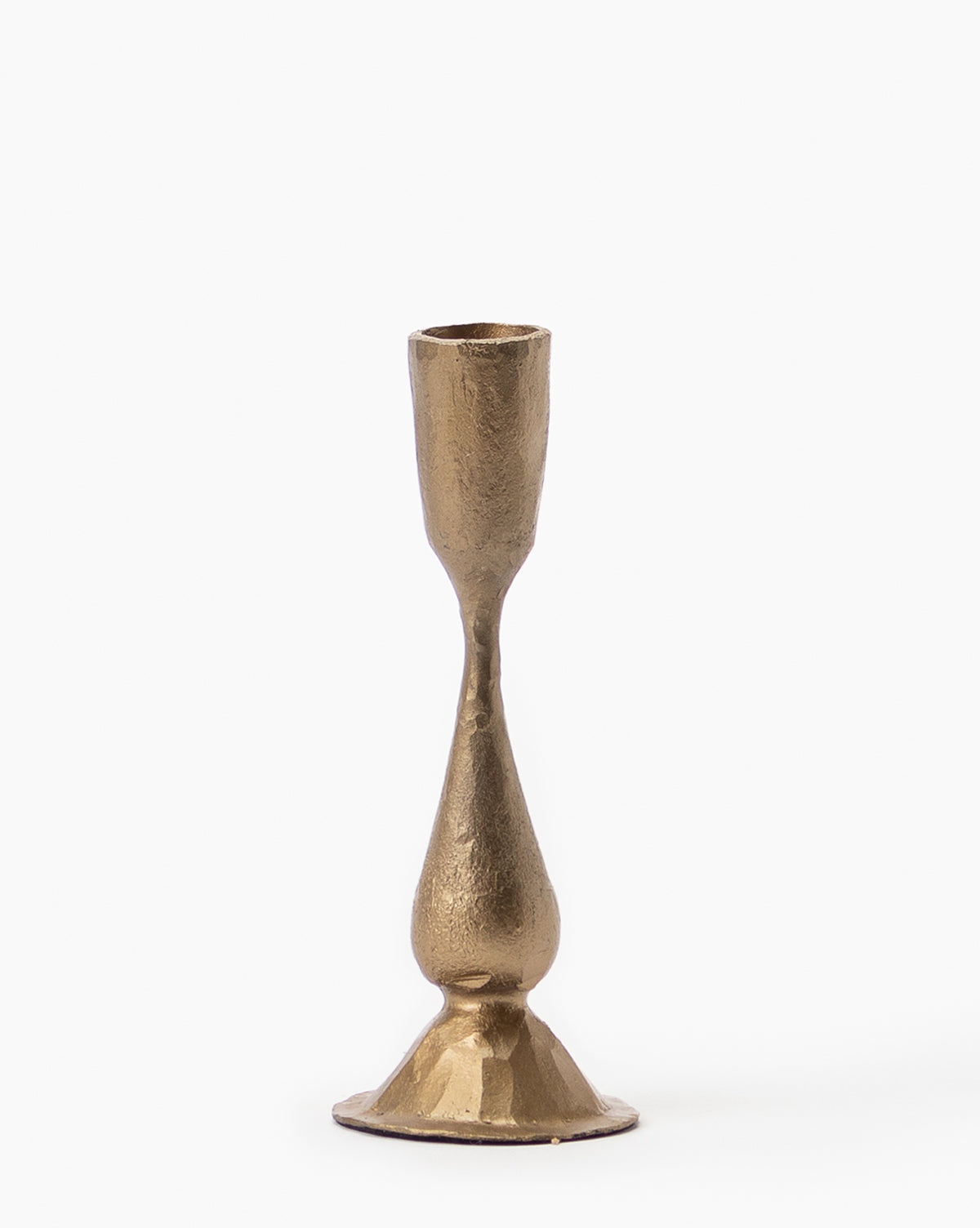 The Antique Brass Taper Candle Holder features a textured surface, a sculptural curving design, and a small round base that highlights its elegant brass finish.