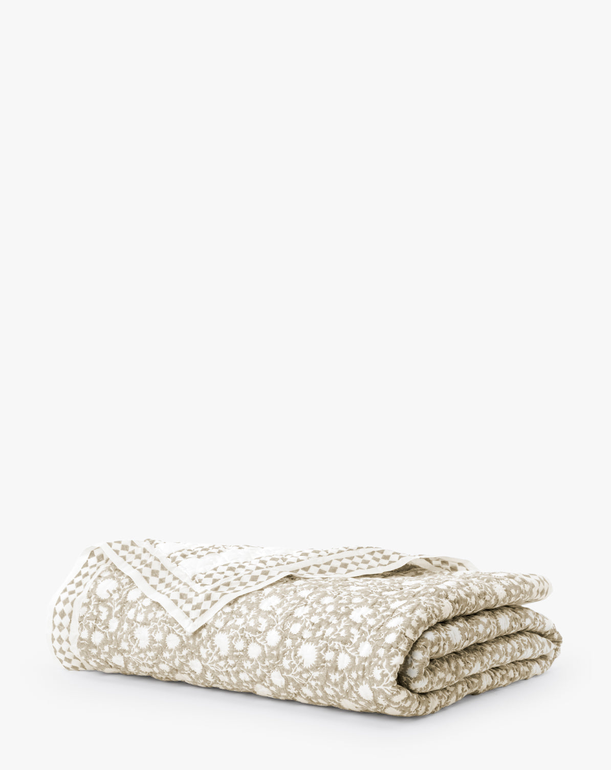 The Arcadia Block Print Kids Quilt, in beige and white with a floral pattern and dotted border, is neatly folded against a plain white background.