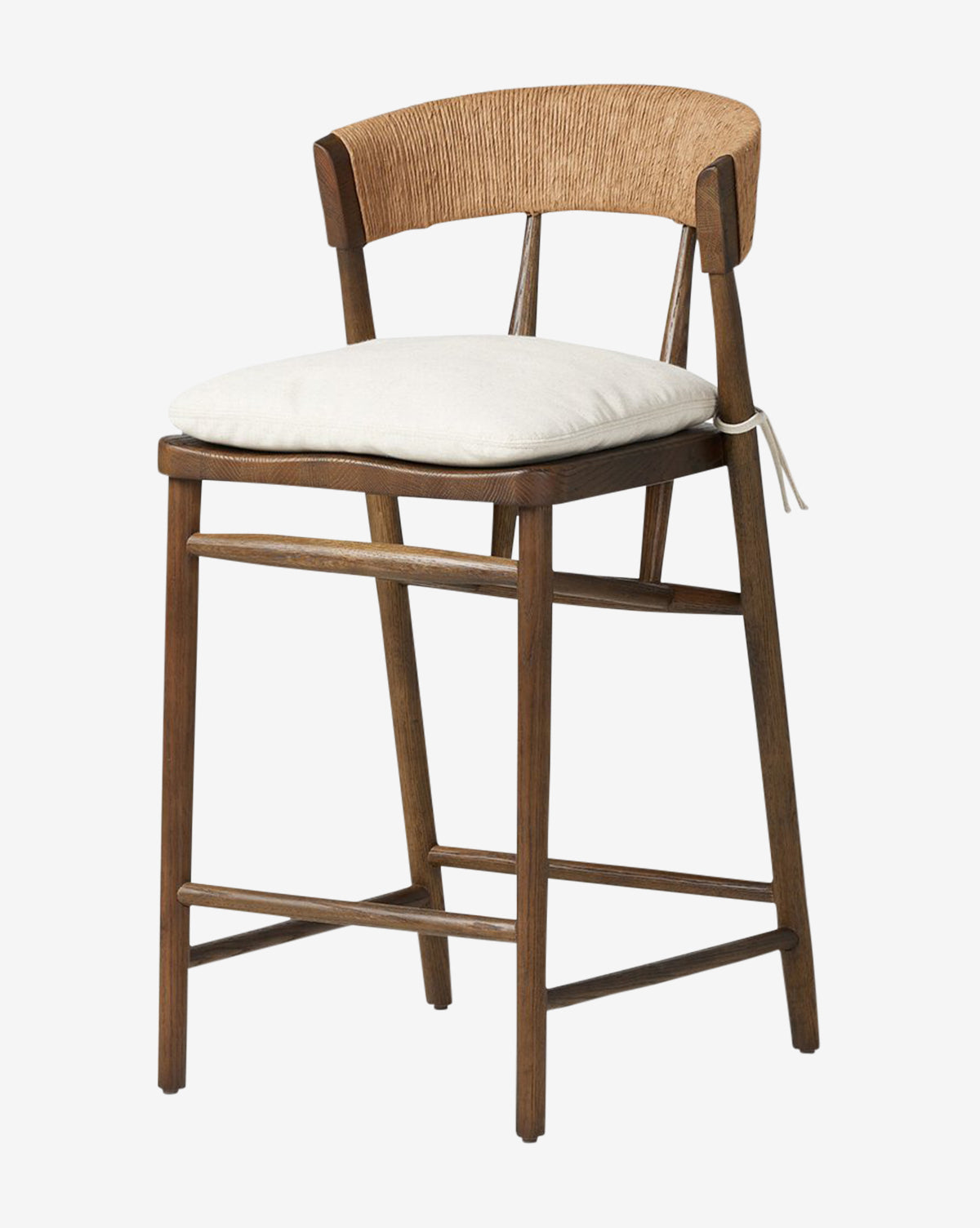 The Ardent Stool by Four Hands features a solid oak frame, curved backrest, woven rattan details, and a light cushioned seat—ideal for kitchen bars. Four sturdy legs with support bars ensure stability and style. McGee & Co.