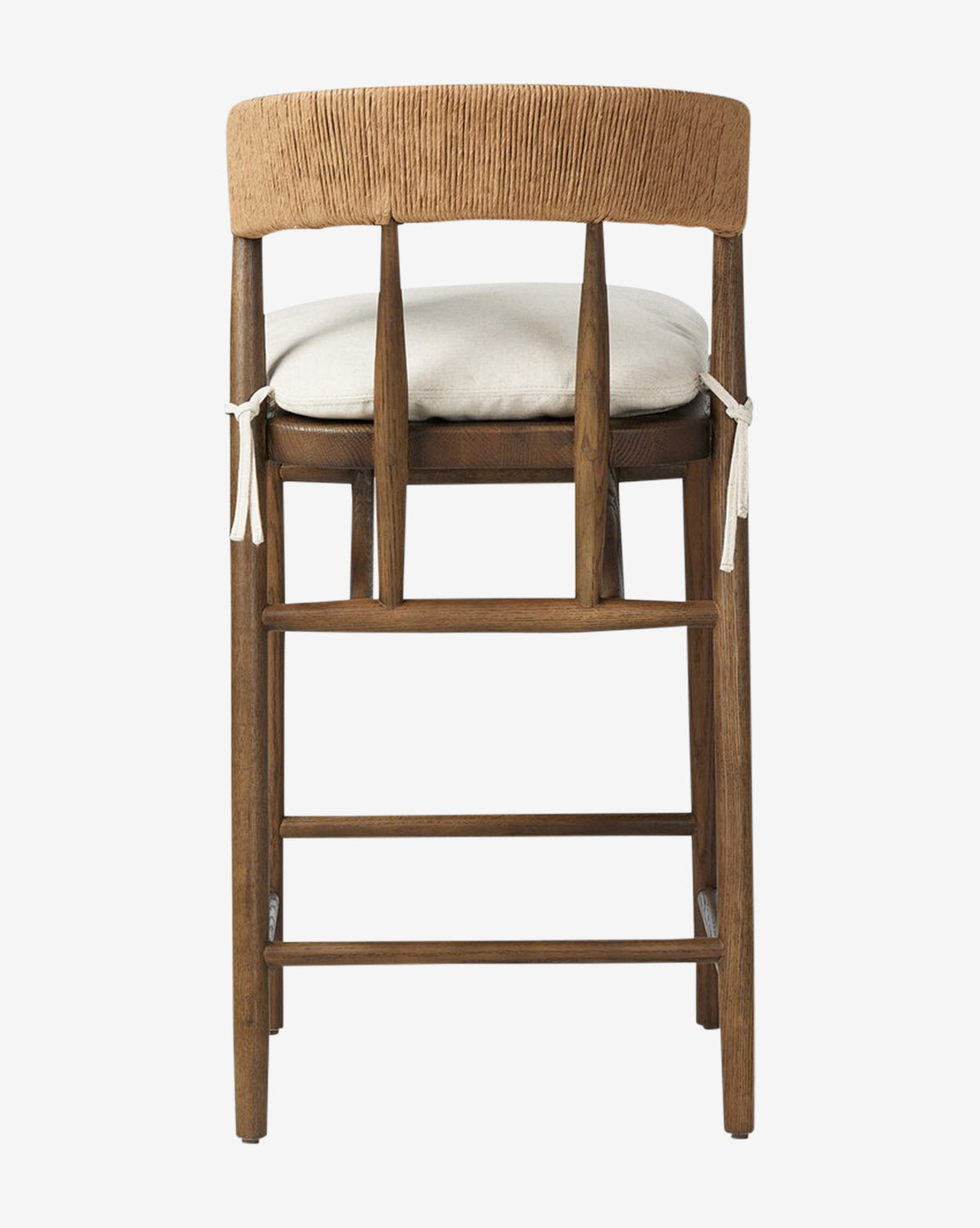 Back view of the Four Hands Ardent Stool, showcasing a curved woven backrest with vertical slats, a light cushioned seat with white ties, and a solid oak frame in a rustic natural finish—ideal for your kitchen bar. McGee & Co.