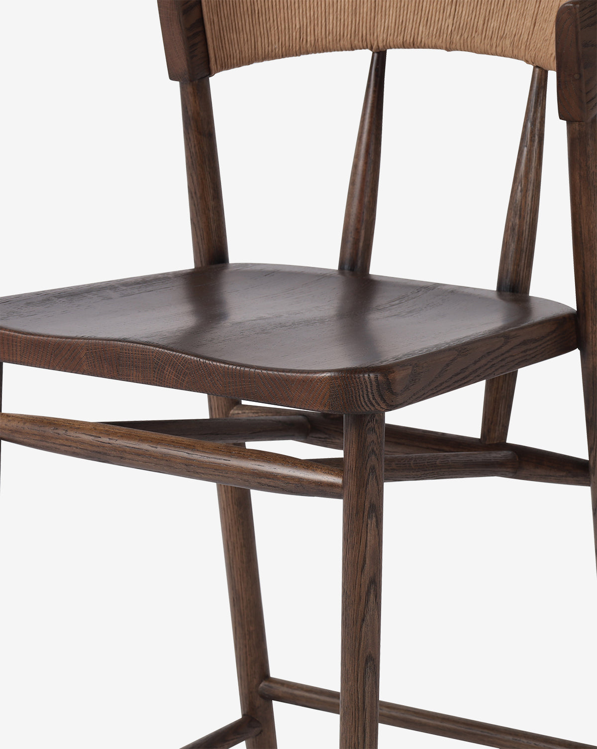 A close-up of the Four Hands Ardent Stool shows its dark brown contoured seat, angled legs, and light brown textured backrest, all set against a white background—McGee & Co.