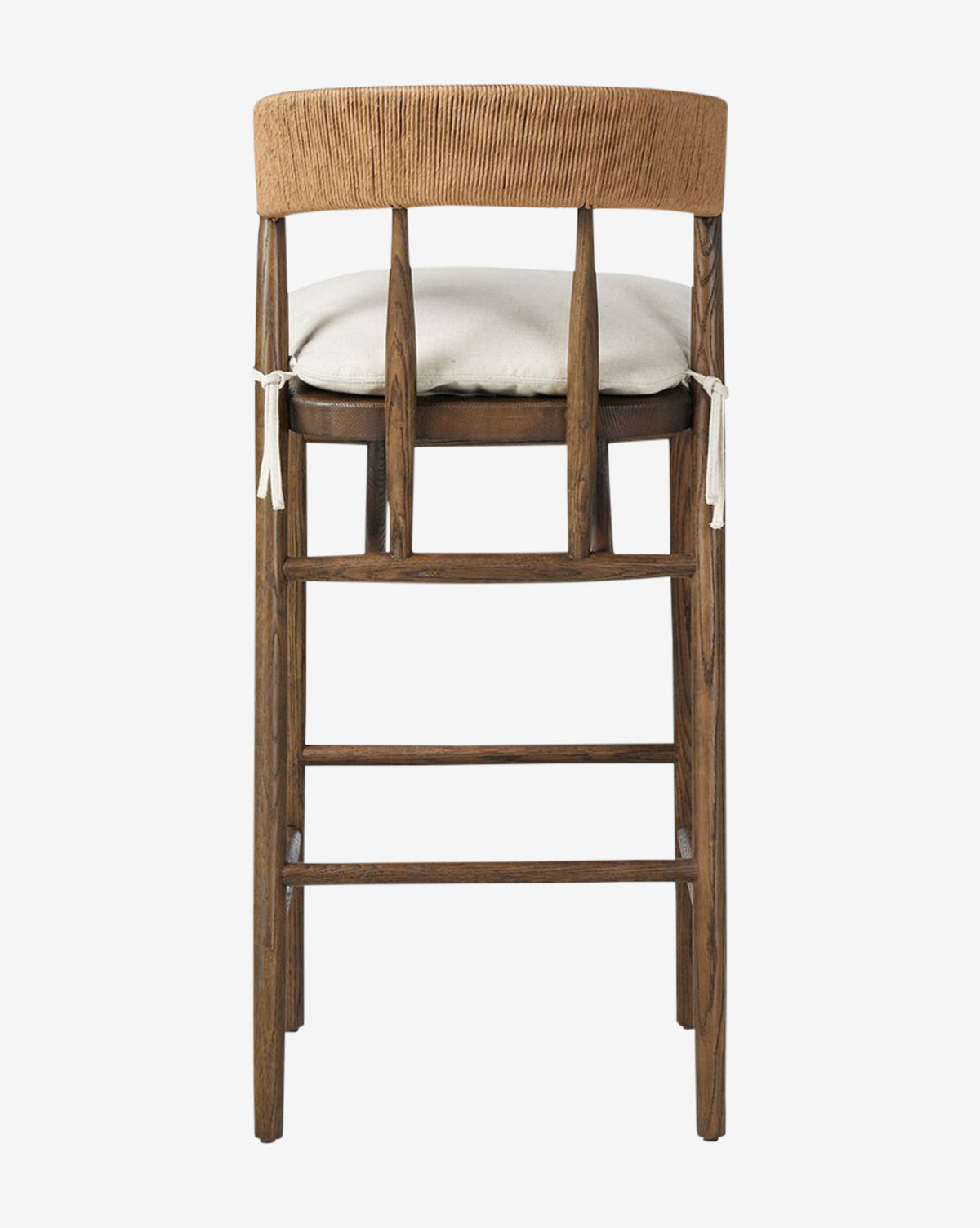 The Ardent Stool by Four Hands features a dark oak frame, a curved light brown backrest, and a light beige cushion with white ties—seen from the back against a white background—making it a stylish choice for your kitchen bar. McGee & Co.