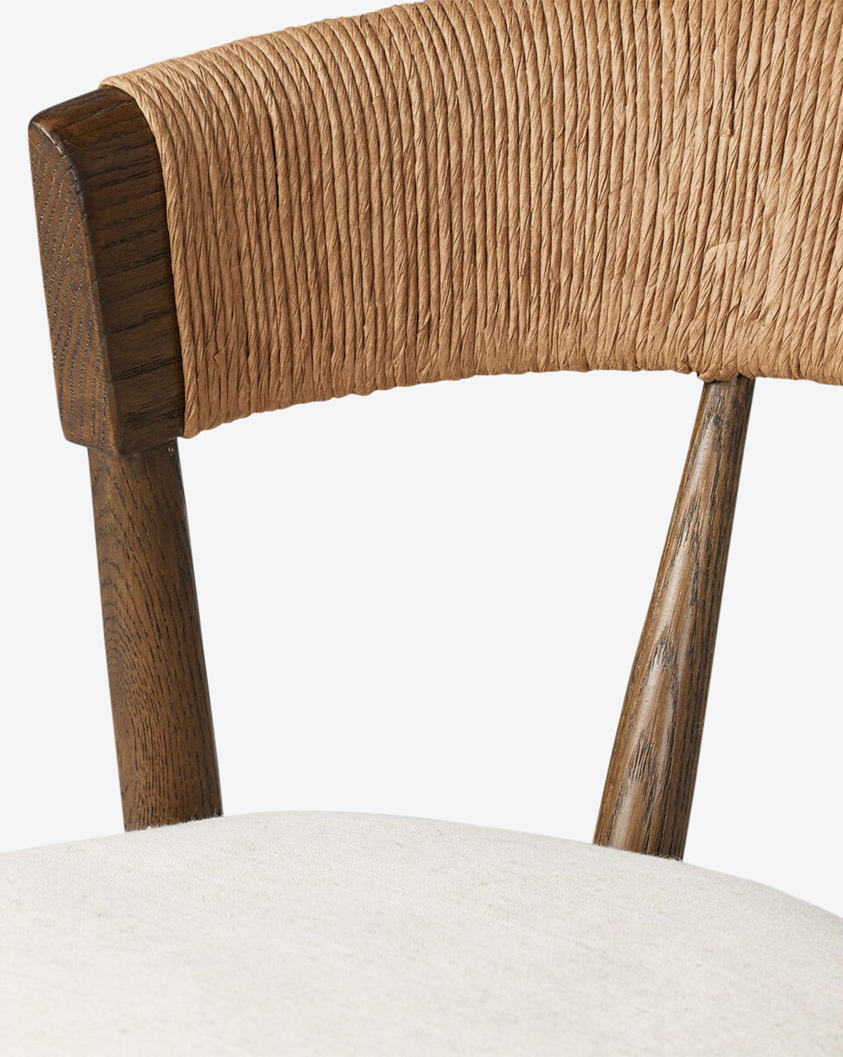 Close-up of the Ardent Stool by Four Hands, showcasing twisted natural paper rush wrapped around the curved backrest, dark wooden supports, and a light cushioned seat. McGee & Co.