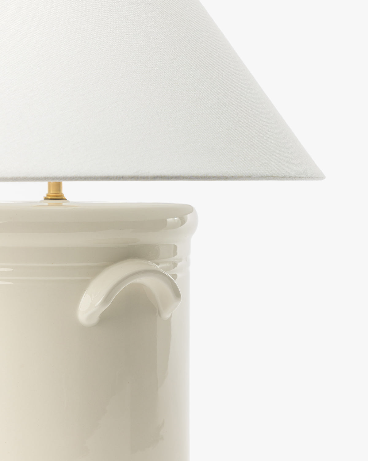 Close-up of the Arles Table Lamp, showcasing its glossy ceramic base with a small handle and a wide white fabric shade—perfect for enhancing your home lighting against a plain white background, by McGee & Co.
