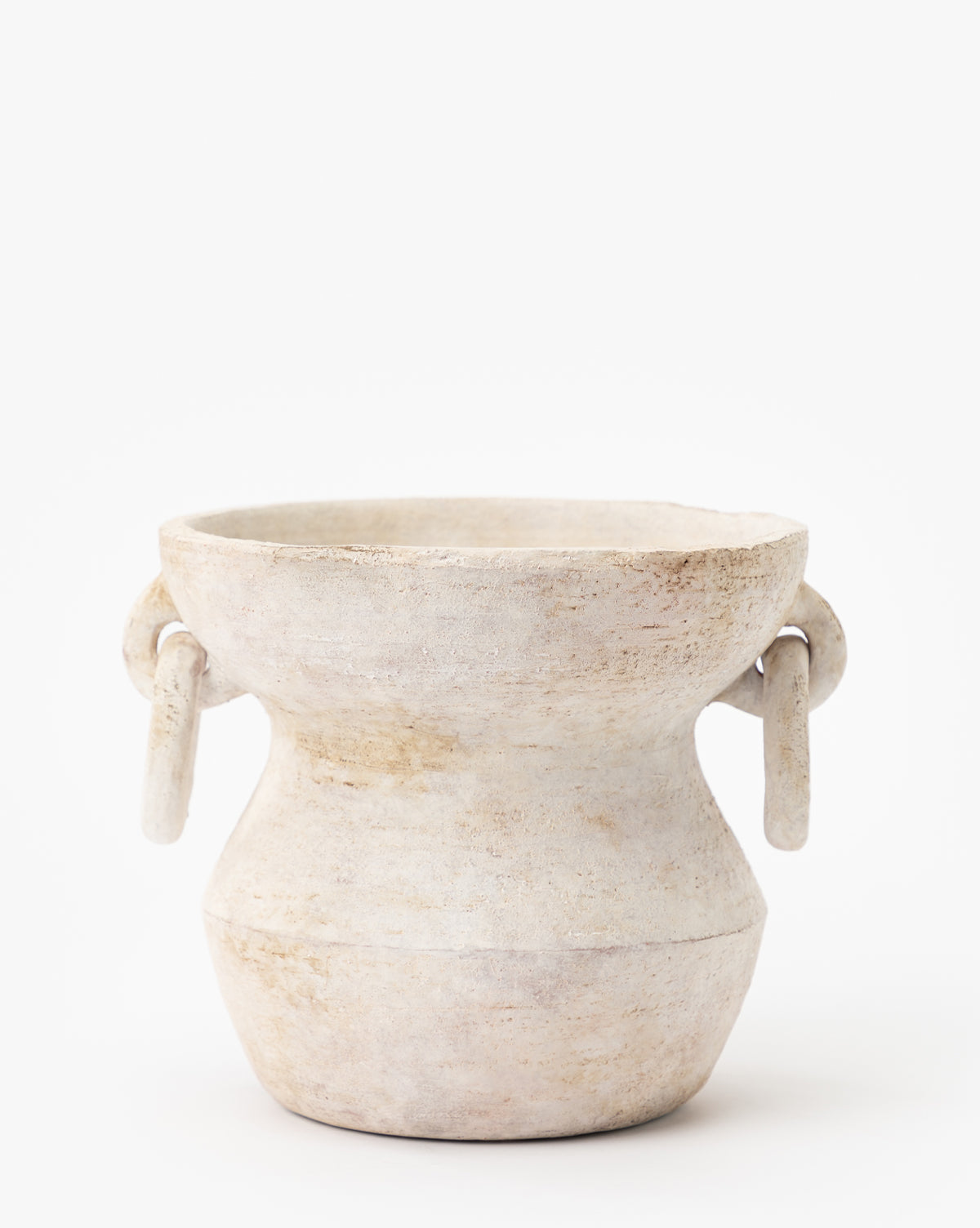The Arnette Terracotta Vase features a round, rustic shape with a stone-colored finish, wide mouth, curved body, and two circular side handles. Its handmade surface is weathered and textured. Displayed against a plain white background.