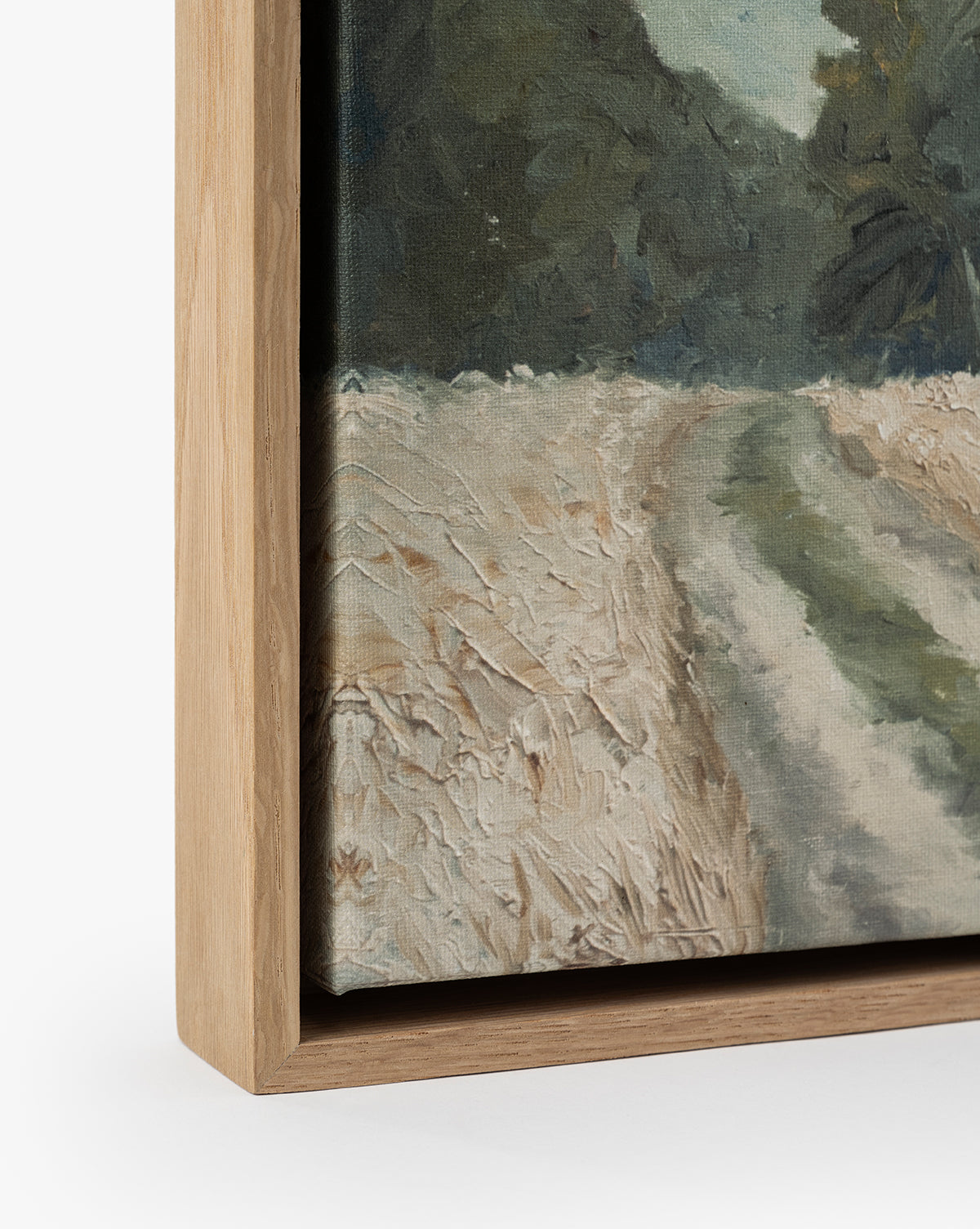 Close-up of Around the Bend, a framed gallery-quality landscape print featuring a textured canvas with a dirt path, grassy area, and trees in natural, muted tones. The light wood frame contrasts with the earthy palette, by McGee & Co.