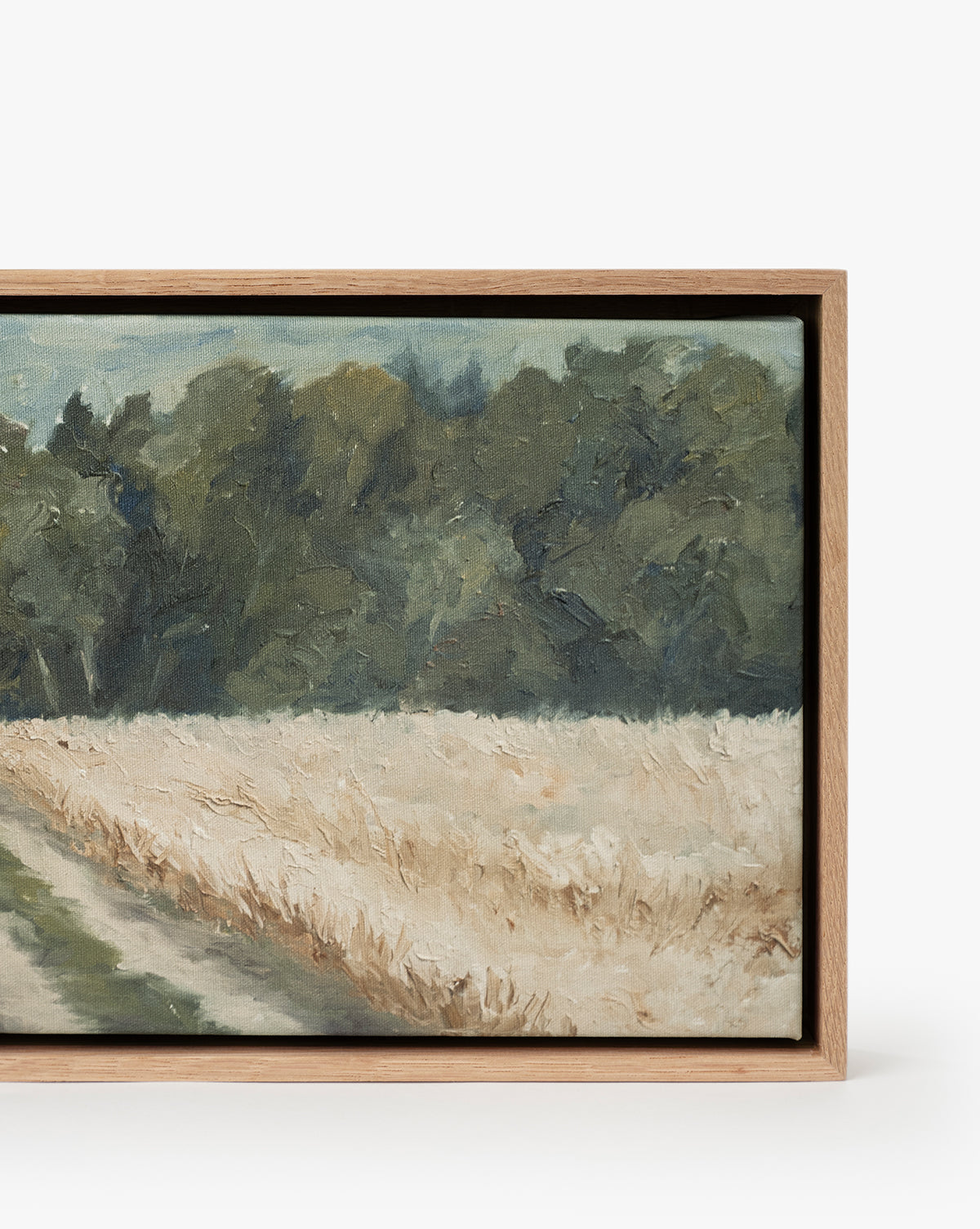 Around the Bend: A framed, gallery-quality landscape fine art print featuring a dirt path by a golden wheat field, with lush green trees and a cloudy sky in the background, by McGee & Co.