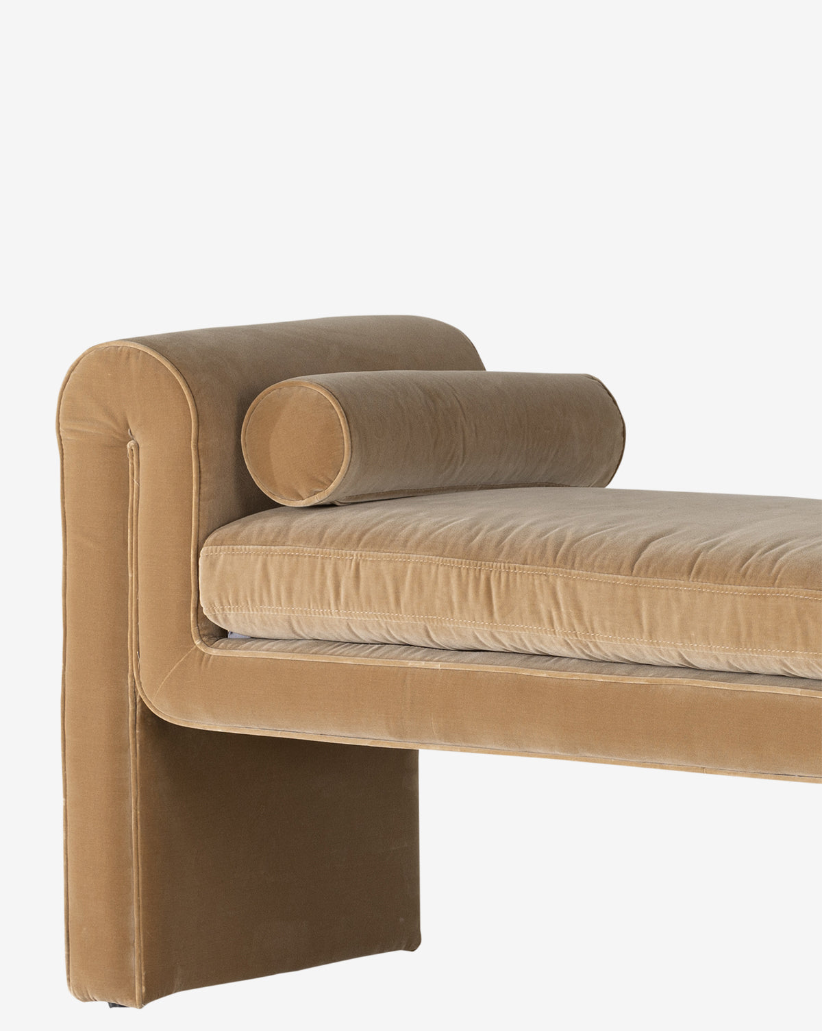 The Ashlyn Bench features modern upholstery in tan velvet with a rectangular backrest, cylindrical bolster pillow, and plush cushioning. Clean lines give it a contemporary style, shown here against a plain white background by McGee & Co.