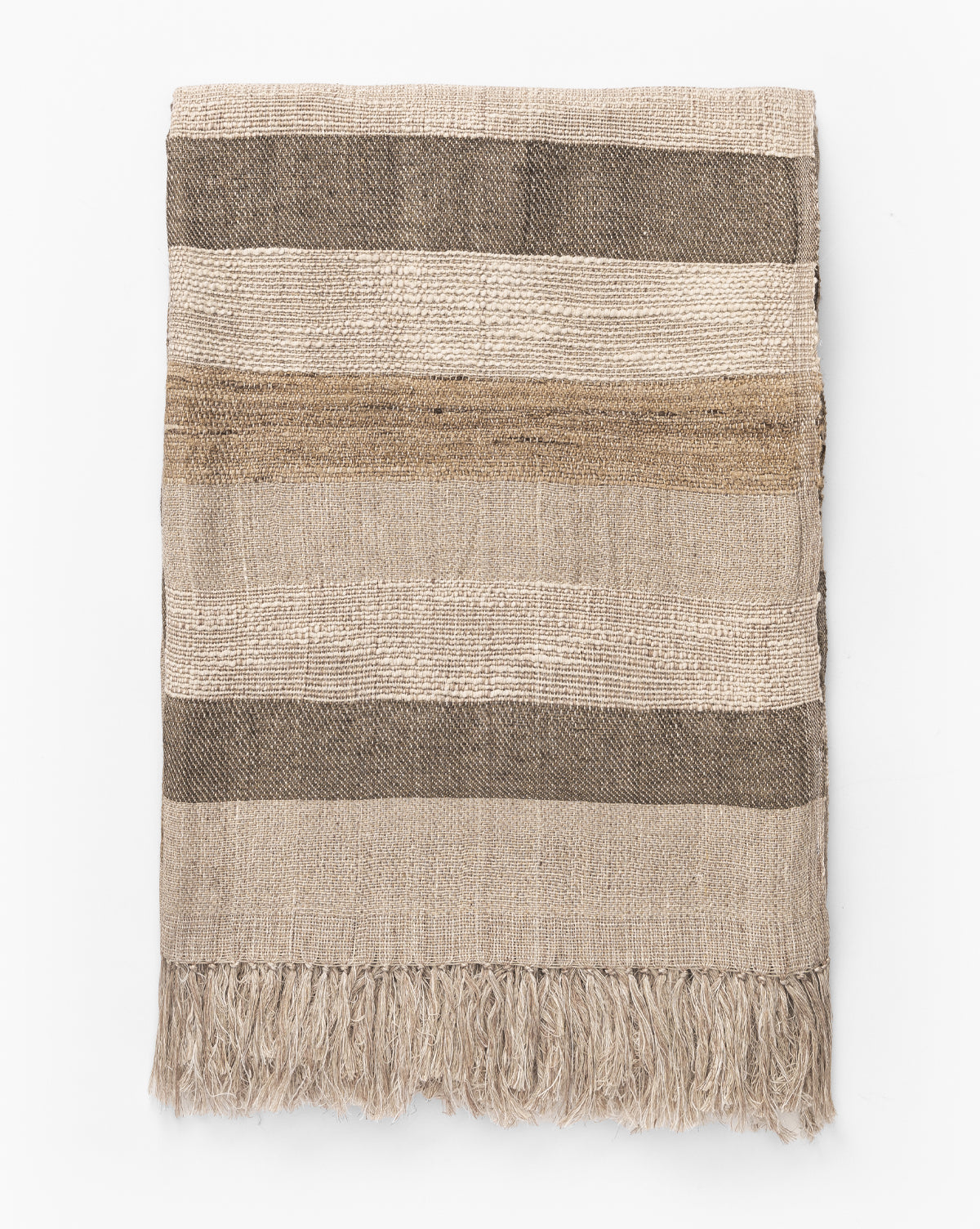 The Ashwood Throw features horizontal stripes in beige, brown, and cream with a textured finish and fringe trim, making it a stylish decorative accent for any sofa.
