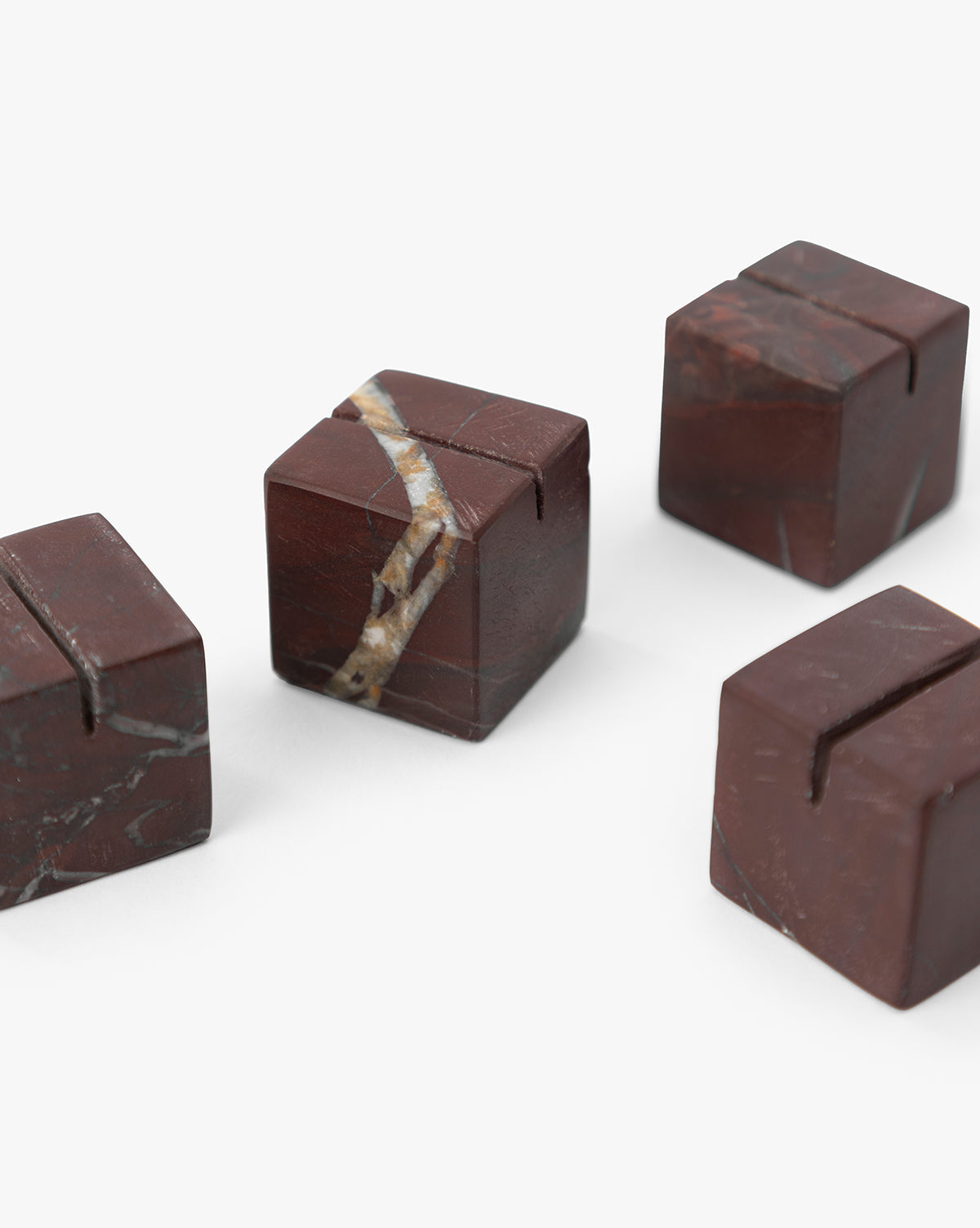 The Auburn Marble Place Card Holders (Set of 4) feature stylish, marble-inspired cubes with a sleek crack detail, bringing a modern touch to your holiday gatherings by McGee & Co.