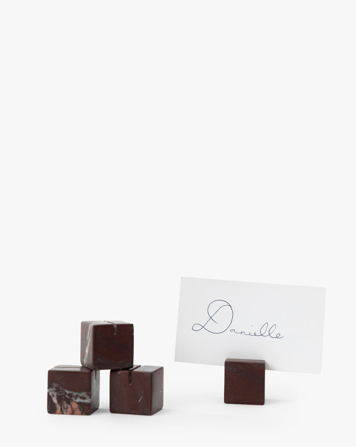 Four dark Auburn Marble Place Card Holders are stacked on the left, with one holding a white Danielle card on the right. These elegant holders are perfect for harvest tablescapes or holiday gatherings. Set of 4, by McGee & Co.