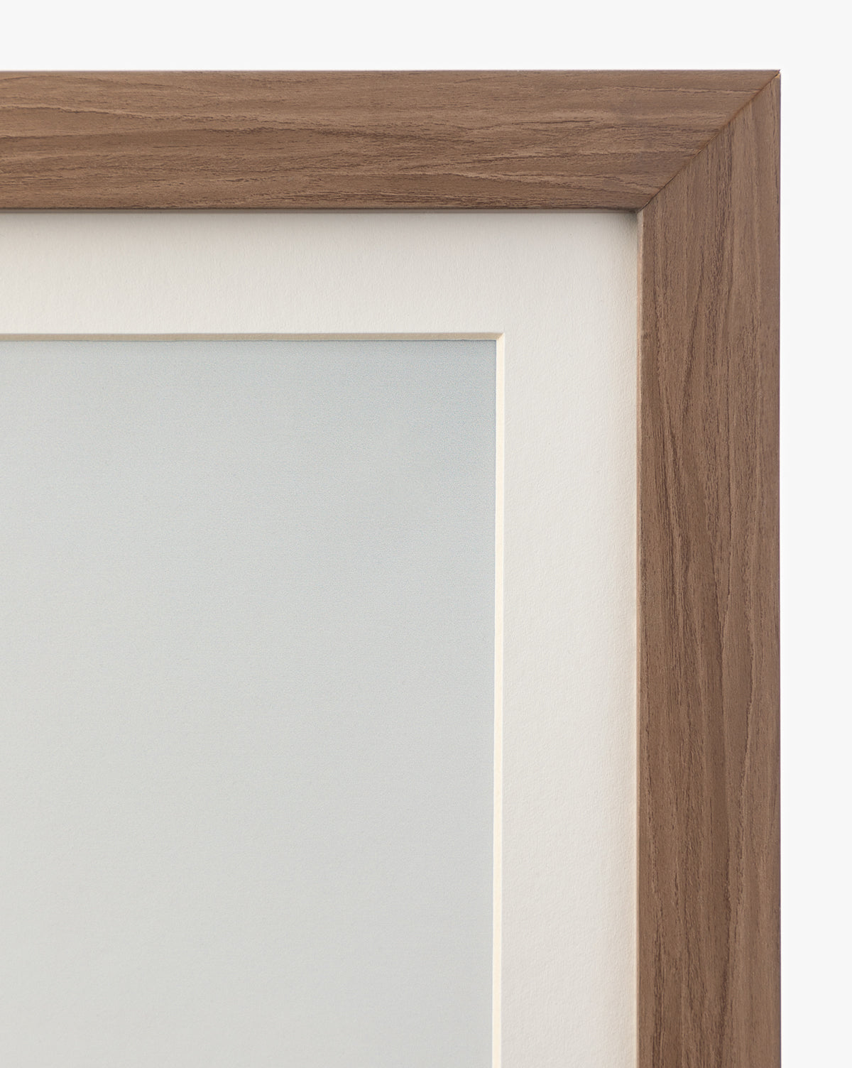 Close-up of the top right corner of a walnut wood frame with a light brown finish, showcasing a white mat board and part of the Autumn Marshes giclee print inside, by McGee & Co.