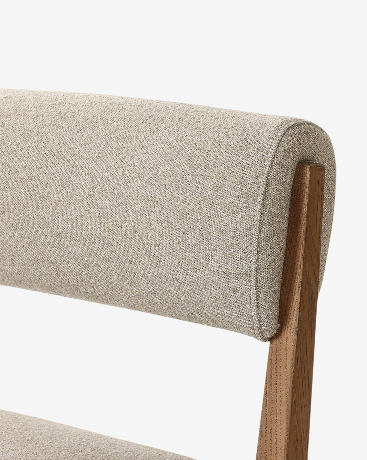 Close-up of the Bailey Dining Chair, showcasing its textured beige upholstered backrest and seat with a smoked oak wooden frame for a modern, minimalist look, by McGee & Co.