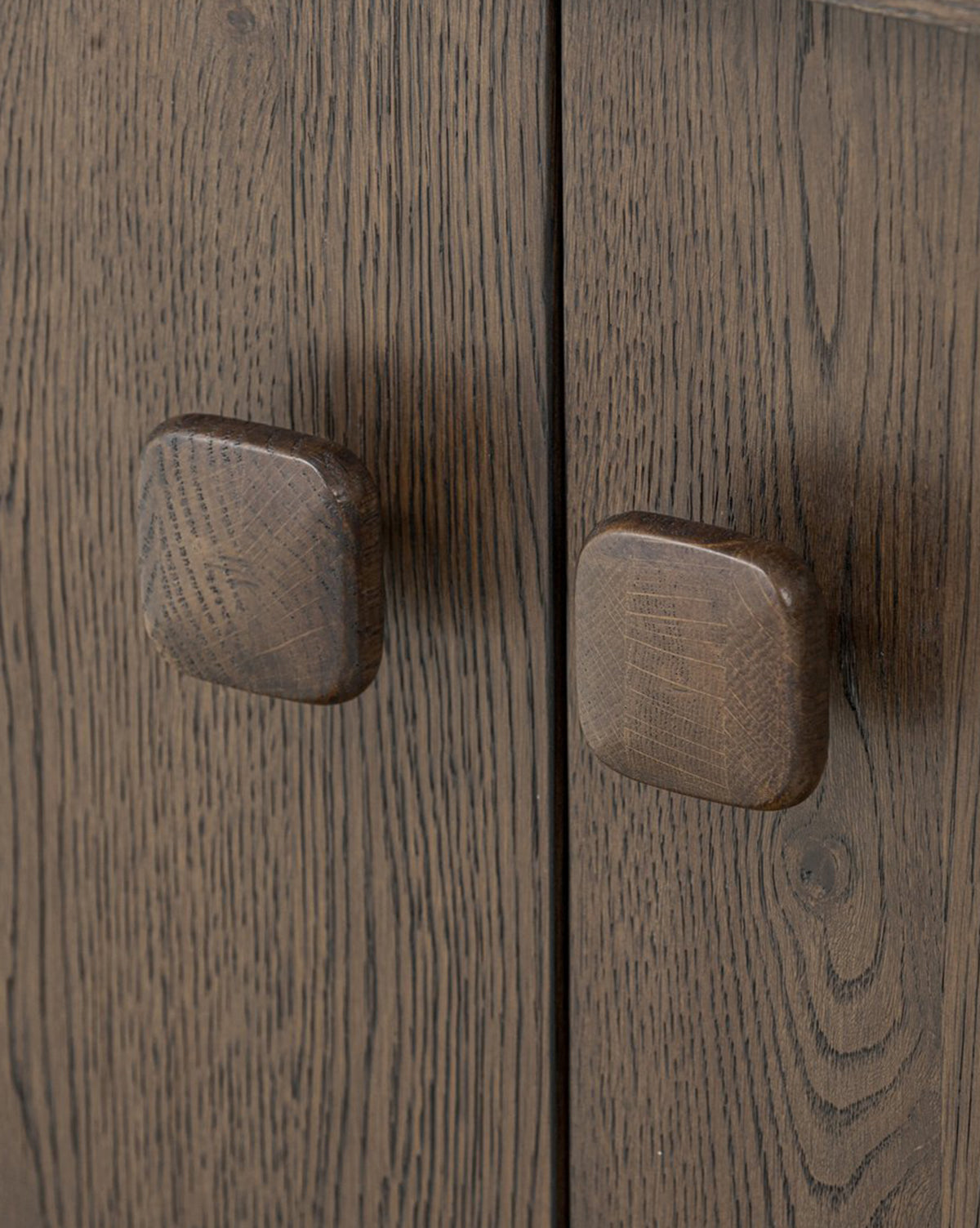 Close-up of two square wooden handles on the Baldwin Sideboard’s dark wood cabinet, showcasing its distinct grain pattern, by McGee & Co.