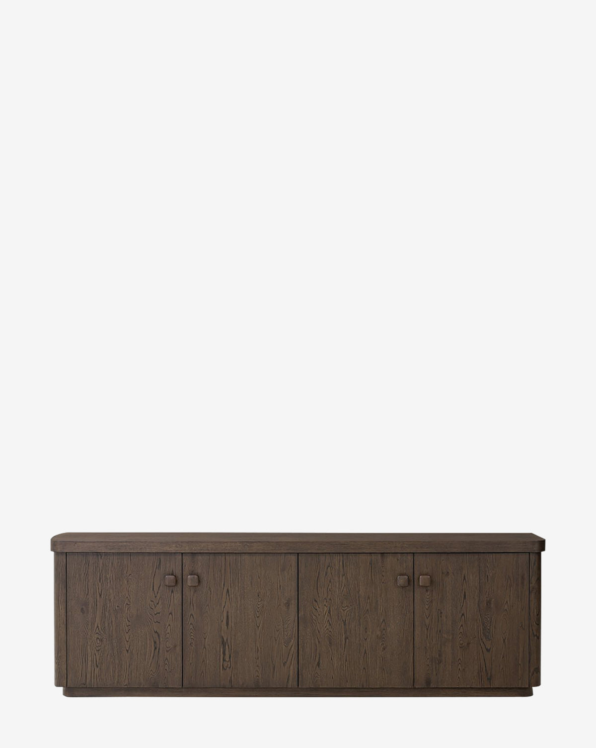 The Baldwin Sideboard in dark brown oak features four cabinet doors, simple square handles, and a natural wood grain texture, displayed against a plain white background by McGee & Co.