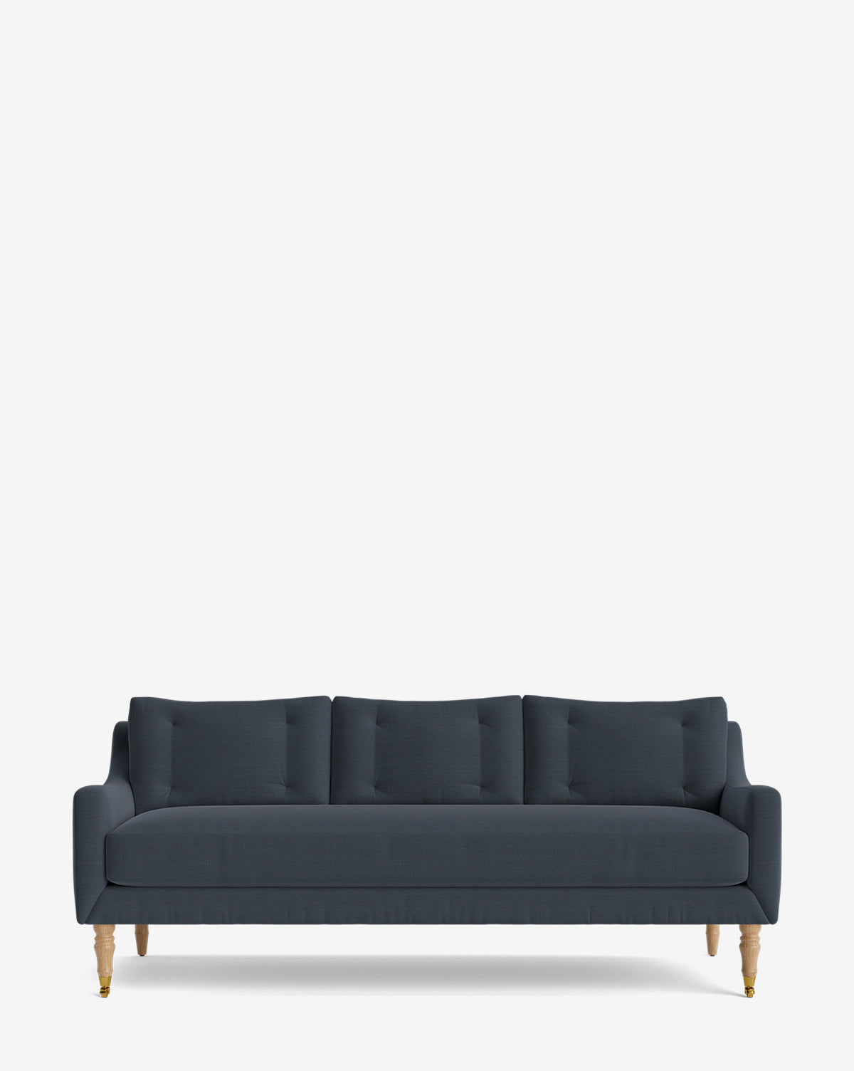A dark blue modern Barden Sofa 84 with three tufted cushions and four reeded wood legs, set against a plain white background by McGee & Co.
