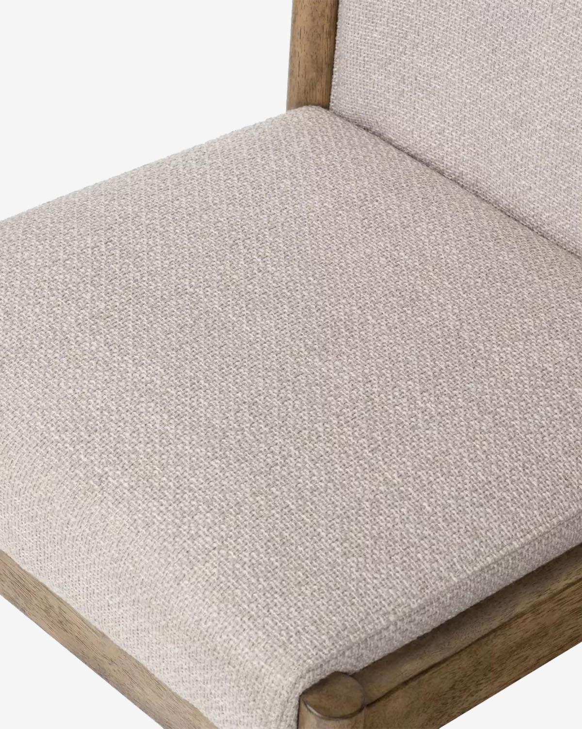 Close-up of the Bardot Dining Chair, showcasing its light beige high-performance fabric seat and backrest with a natural-finish parawood frame and visible grain, by McGee & Co.