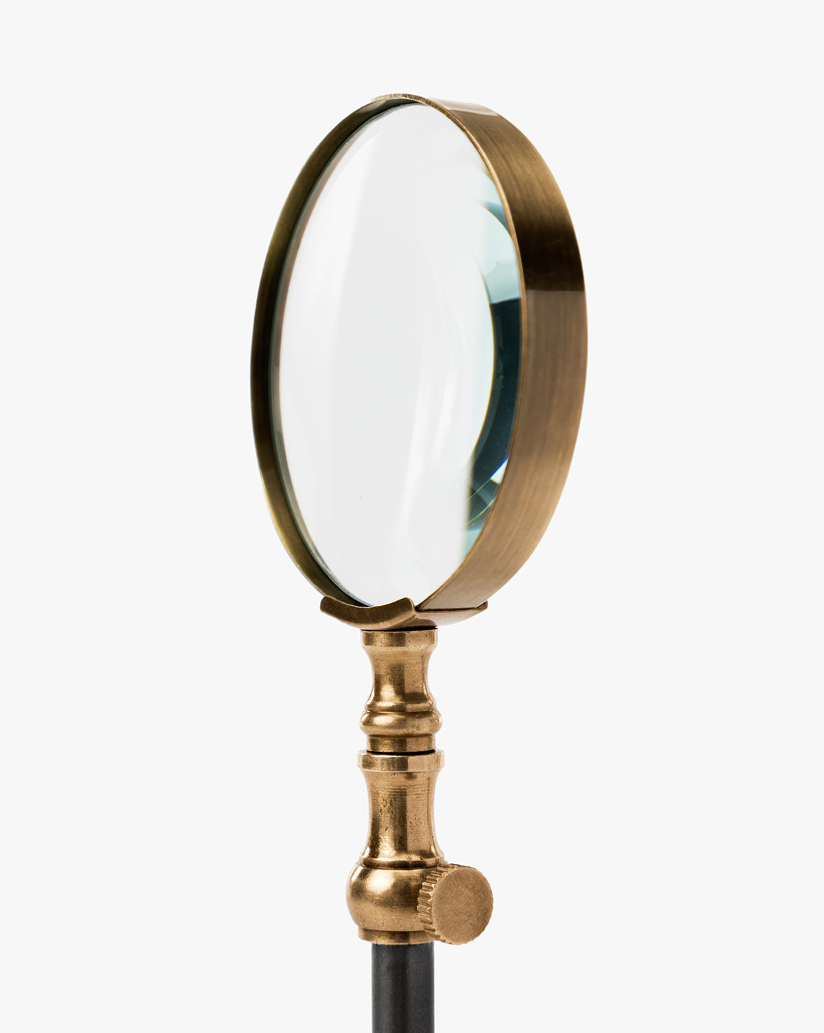 The Barnabas Standing Object features a vintage round clear lens and a burnished brass handle, standing upright against a white background—an ideal accent to bring classic charm to your home decor, by McGee & Co.