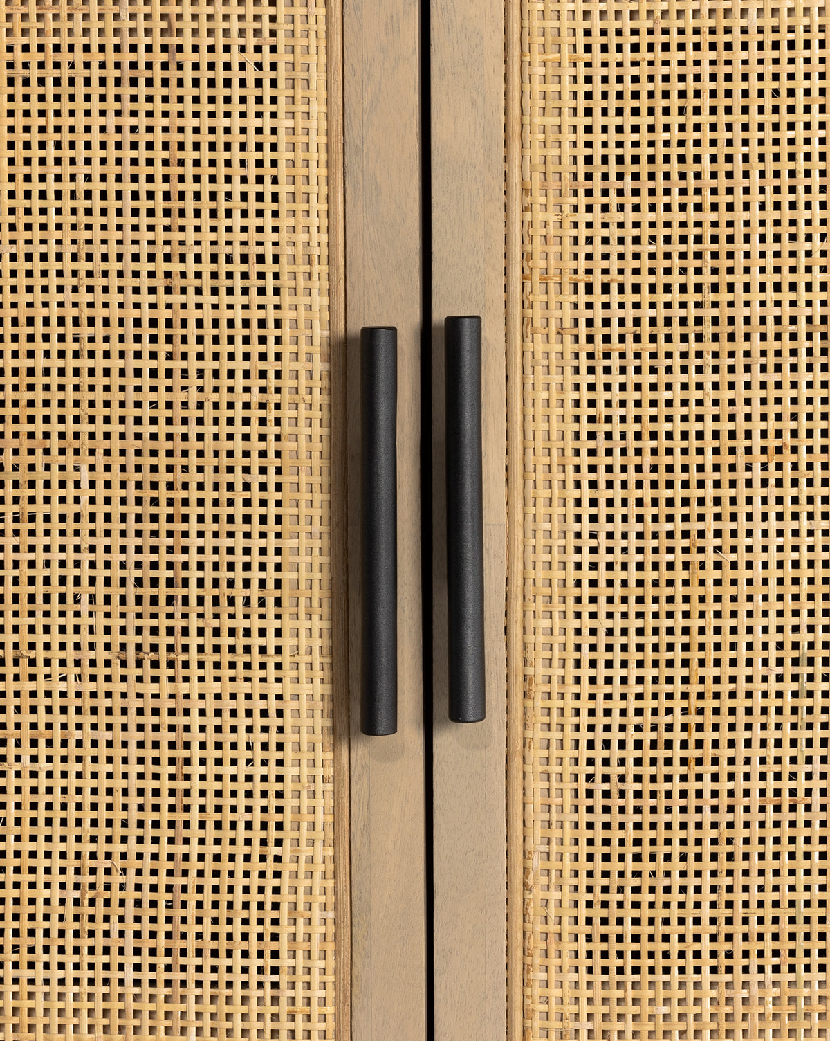 Close-up of two black handles on double cane doors of the Barney Cabinet, a modern storage piece featuring light wood with a woven rattan pattern by McGee & Co.