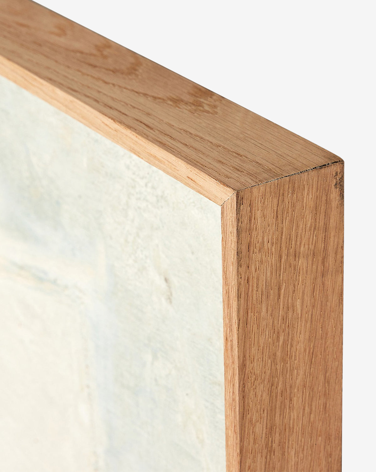 Close-up of the corner of a wooden frame for Basalt by Paul Meyer, featuring light abstract canvas art and emphasizing the natural wood grain and crisp mitered edge, by McGee & Co.