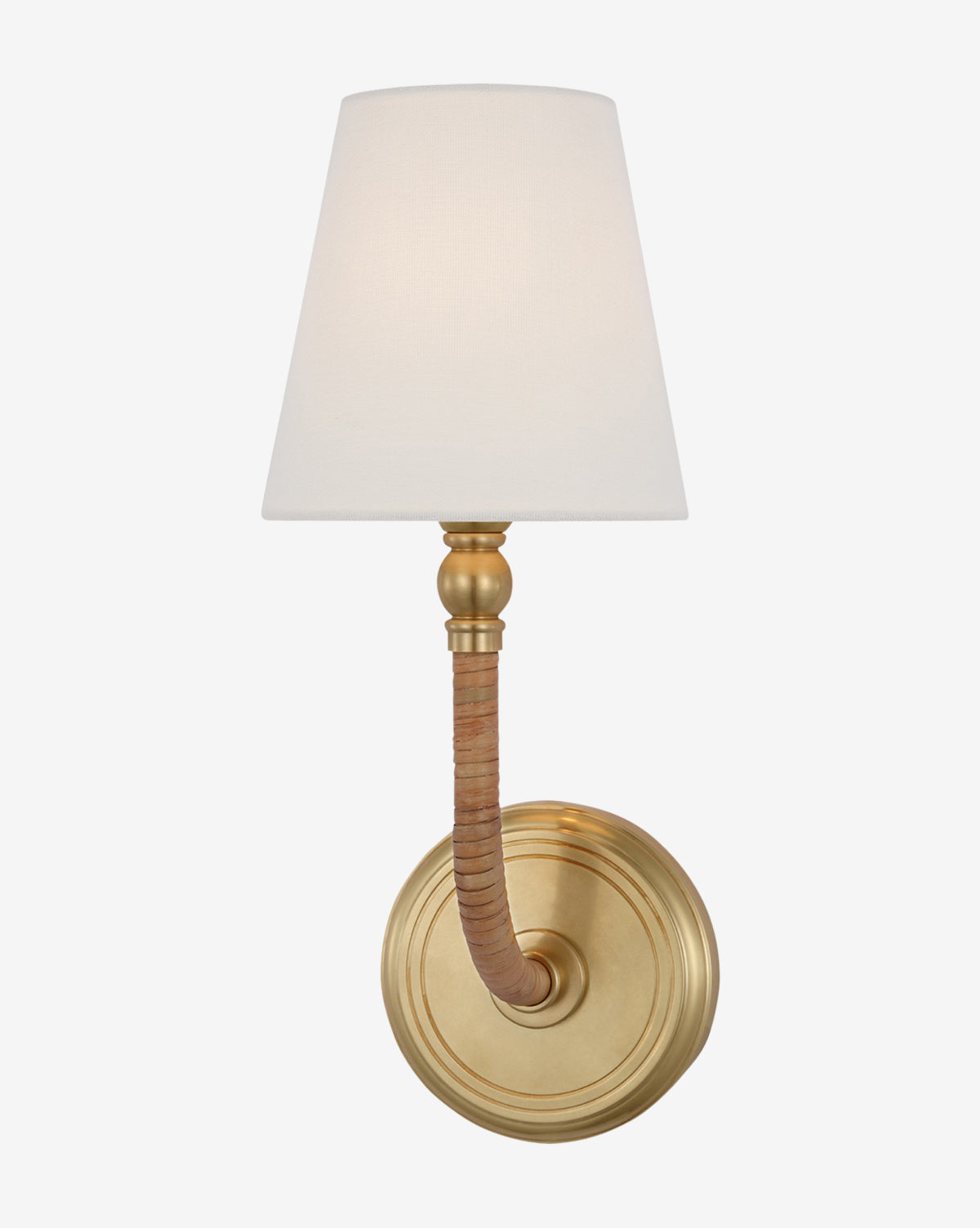 The Visual Comfort & Co. Signature Basden Medium Sconce is wall-mounted with a brass finish, round base, curved arm wrapped in tan material, and a white linen shade, offering a classic, elegant look. McGee & Co.