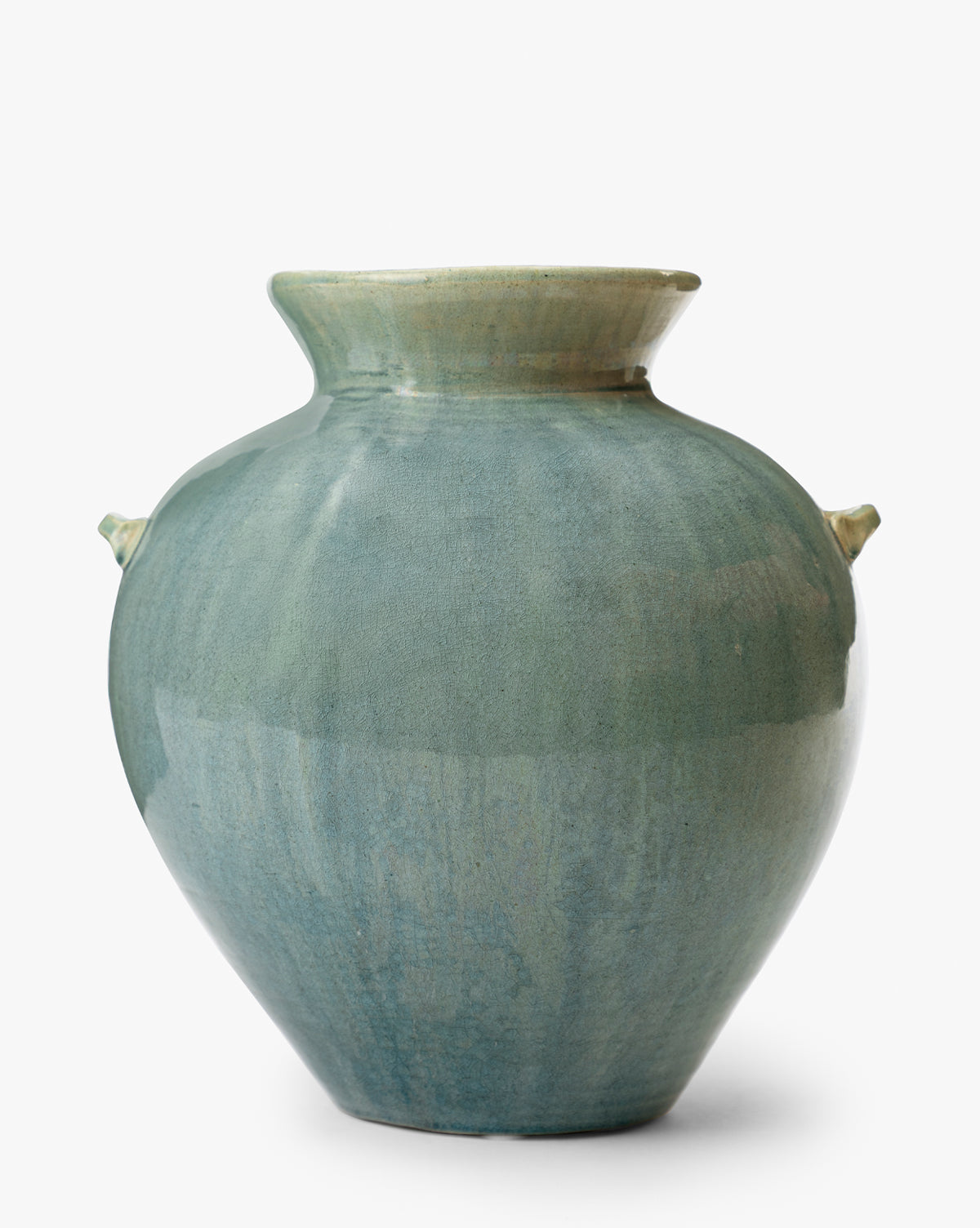 The Beatrix Vase is a large, round ceramic piece with a wide flared rim and small side handles, featuring handcrafted artistry and a smooth greenish-blue glossy glaze, beautifully displayed against a white background, by McGee & Co.