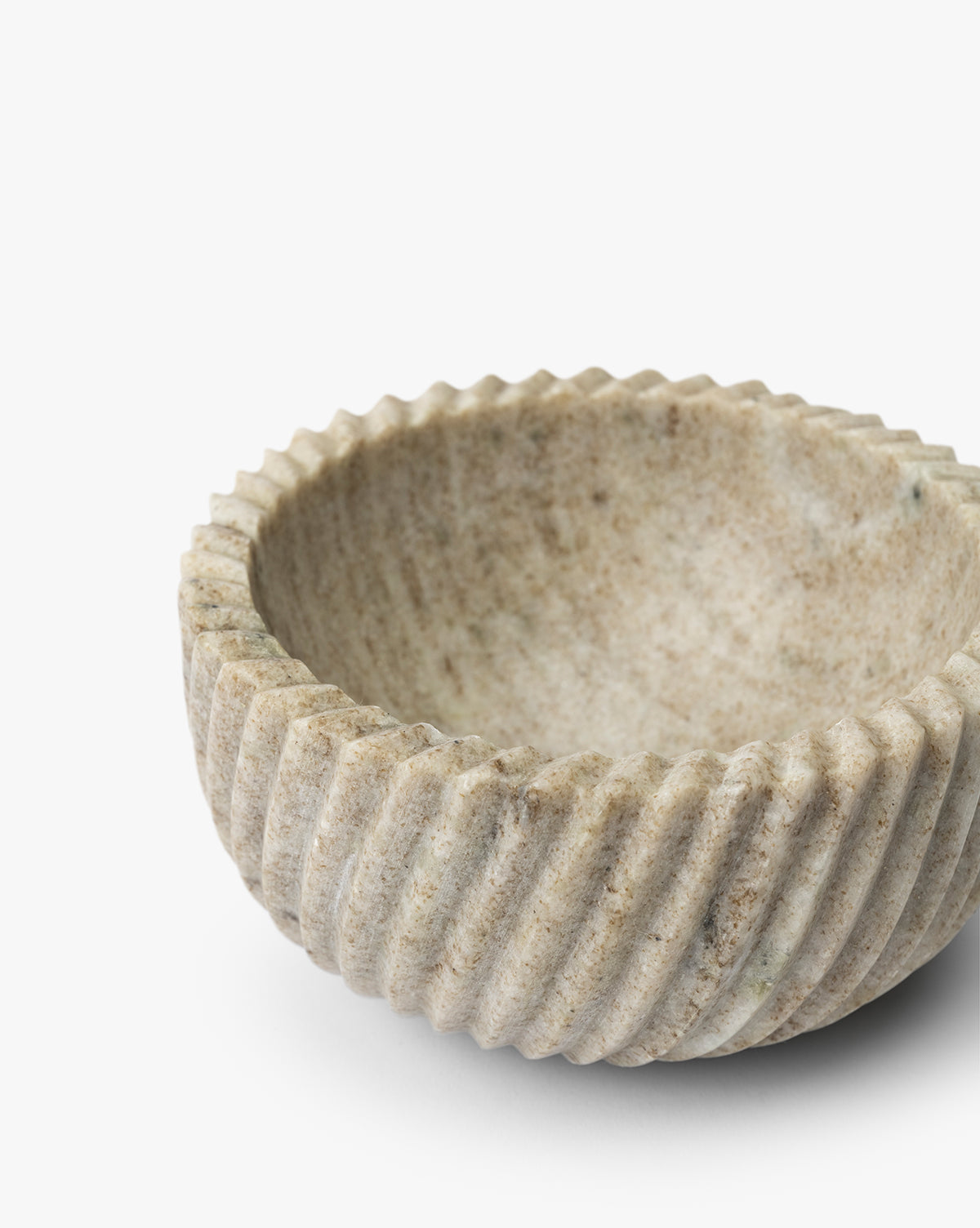 The Beige Spiral Marble Bowl is a round, shallow serving bowl featuring a rough light beige surface with deep diagonal grooves along the exterior, shown on a white background by McGee & Co.