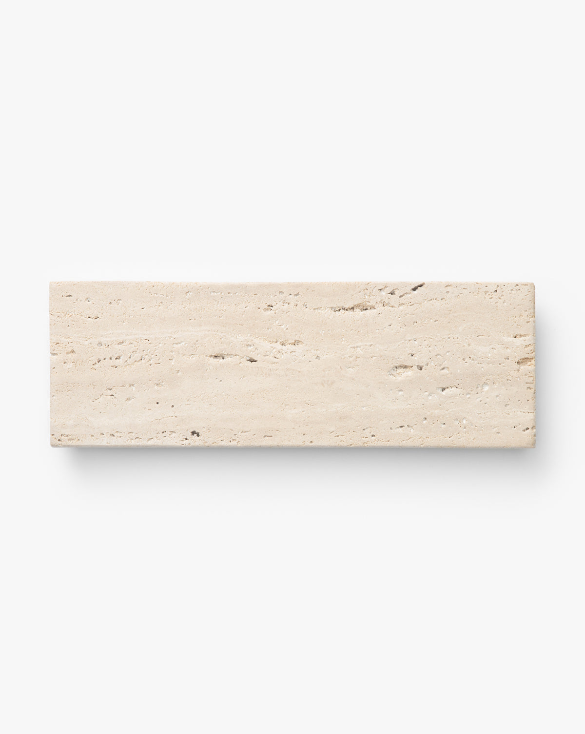 The Beige Travertine Footed Serving Board features a rectangular shape, rough textured surface, and natural horizontal veins, shown against a plain white background, by McGee & Co.