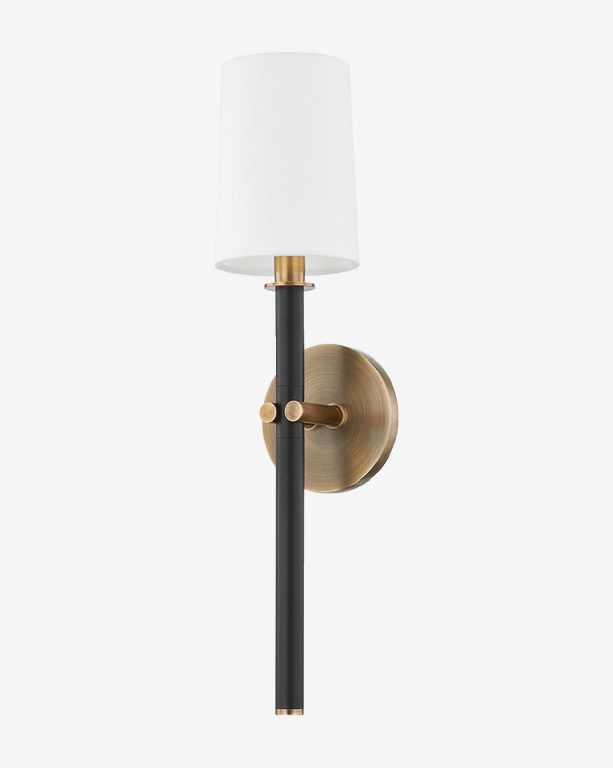 The Belvedere Sconce by Troy Lighting features a black vertical rod, patina brass accents, a round brass wall plate, and a cylindrical white linen shade at the top. McGee & Co.
